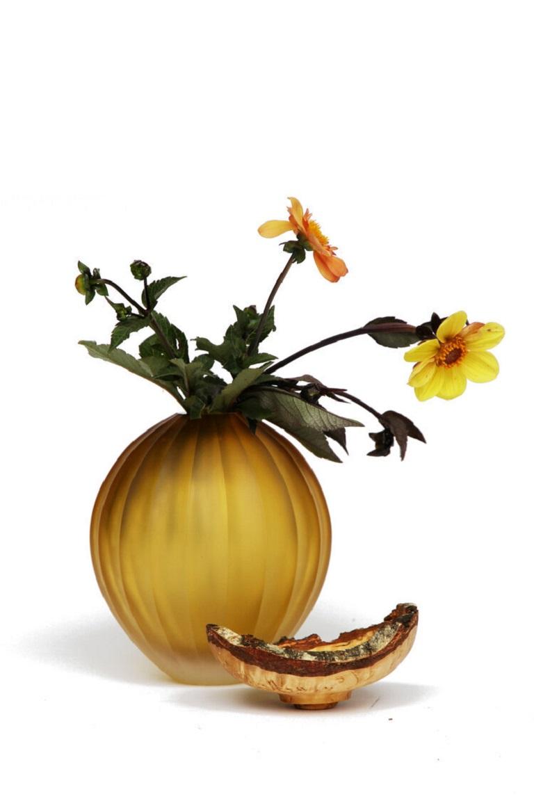 Bernsteinfarbenes Mohnstapelgefäß, Pia Wüstenberg
Abmessungen: D 17 x H 25
MATERIALIEN: geschliffenes Glas, Holz

Mit seinem skulpturalen Glas, das von Curly Birch gekrönt wird, ist Poppy ein exquisites Gefäß. Dieses reizvolle Stück hat sein Erbe in