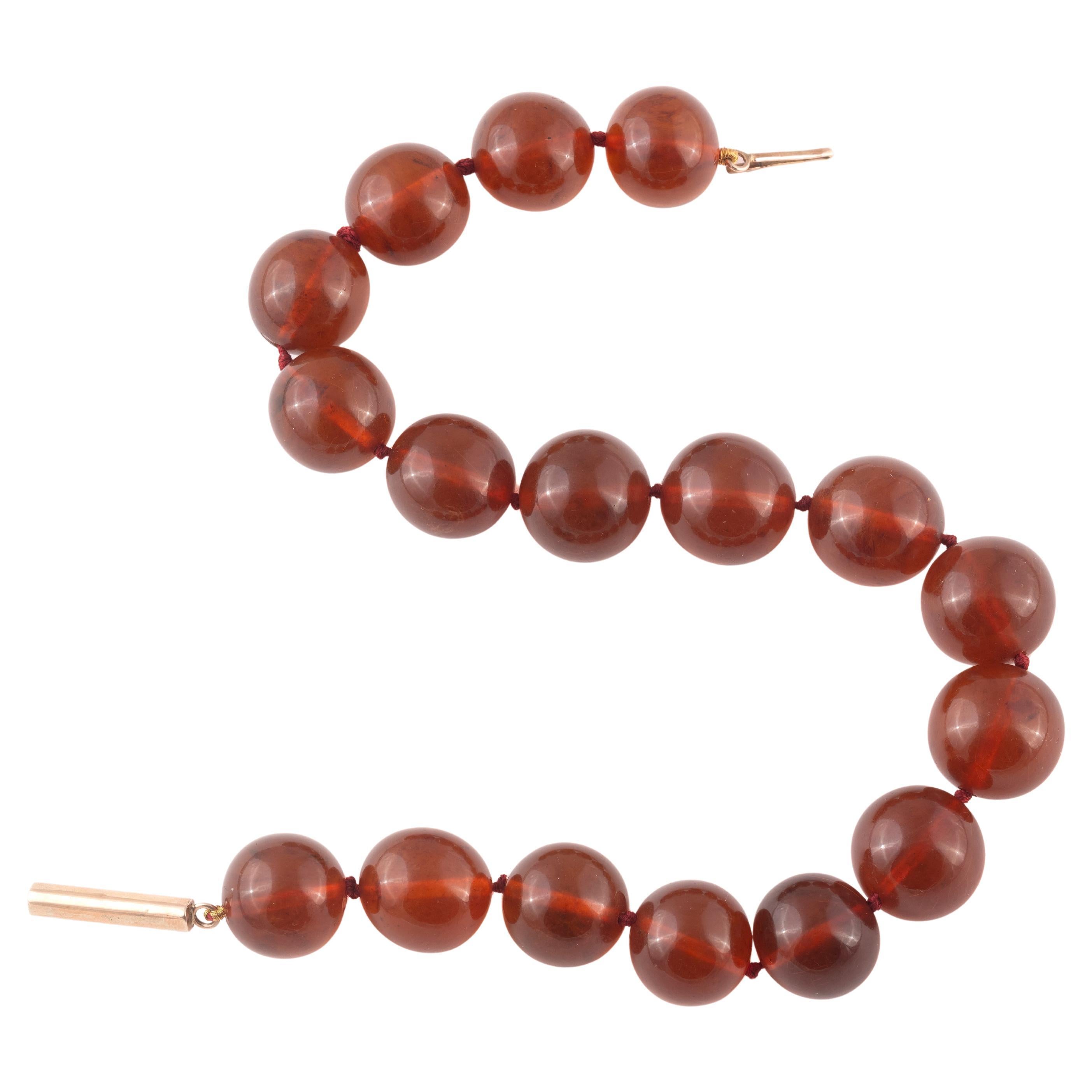 Il filo singolo di perle d'ambra rotonde leggermente graduate che vanno da circa 21 mm a 19 mm.
Il fermaglio montato in oro.
Lunghezza 40 cm.
Peso totale: 70,08 gr