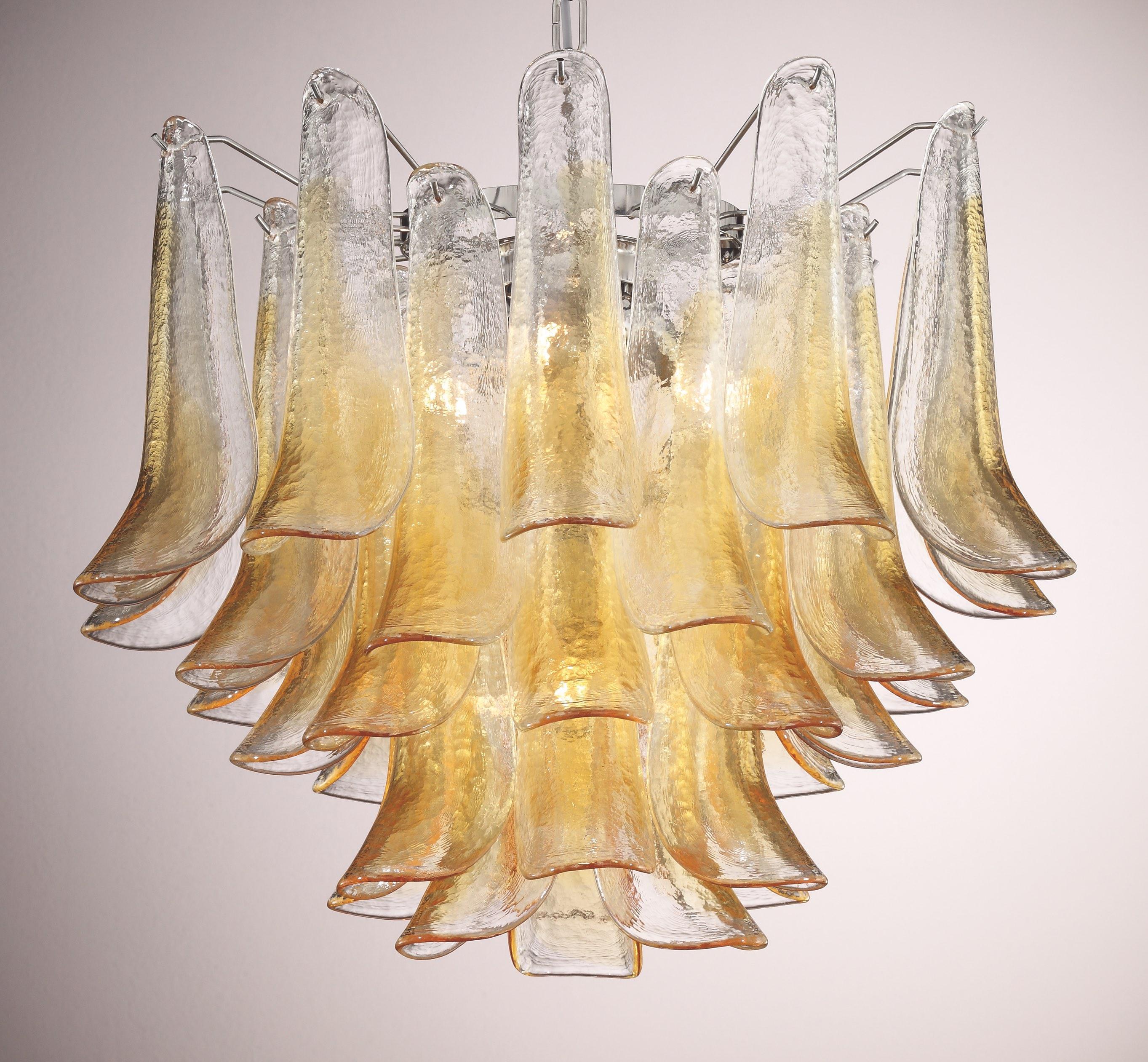 Lámpara de araña italiana con pétalos de cristal de Murano transparente y ámbar montados sobre una estructura metálica cromada / Diseñada por Fabio Bergomi para Fabio Ltd, inspirada en Mazzega / Fabricada en Italia
5 luces / tipo E26 o E27 / máx.