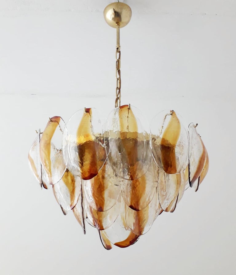 Original Italian chandelier with layers of amber and clear shell shaped Murano glasses mounted on brass frame by La Murrina / Made in Italy circa 1960s
Original mark on glasses
Measures: diameter 20.5 inches, height 20 inches plus chain and