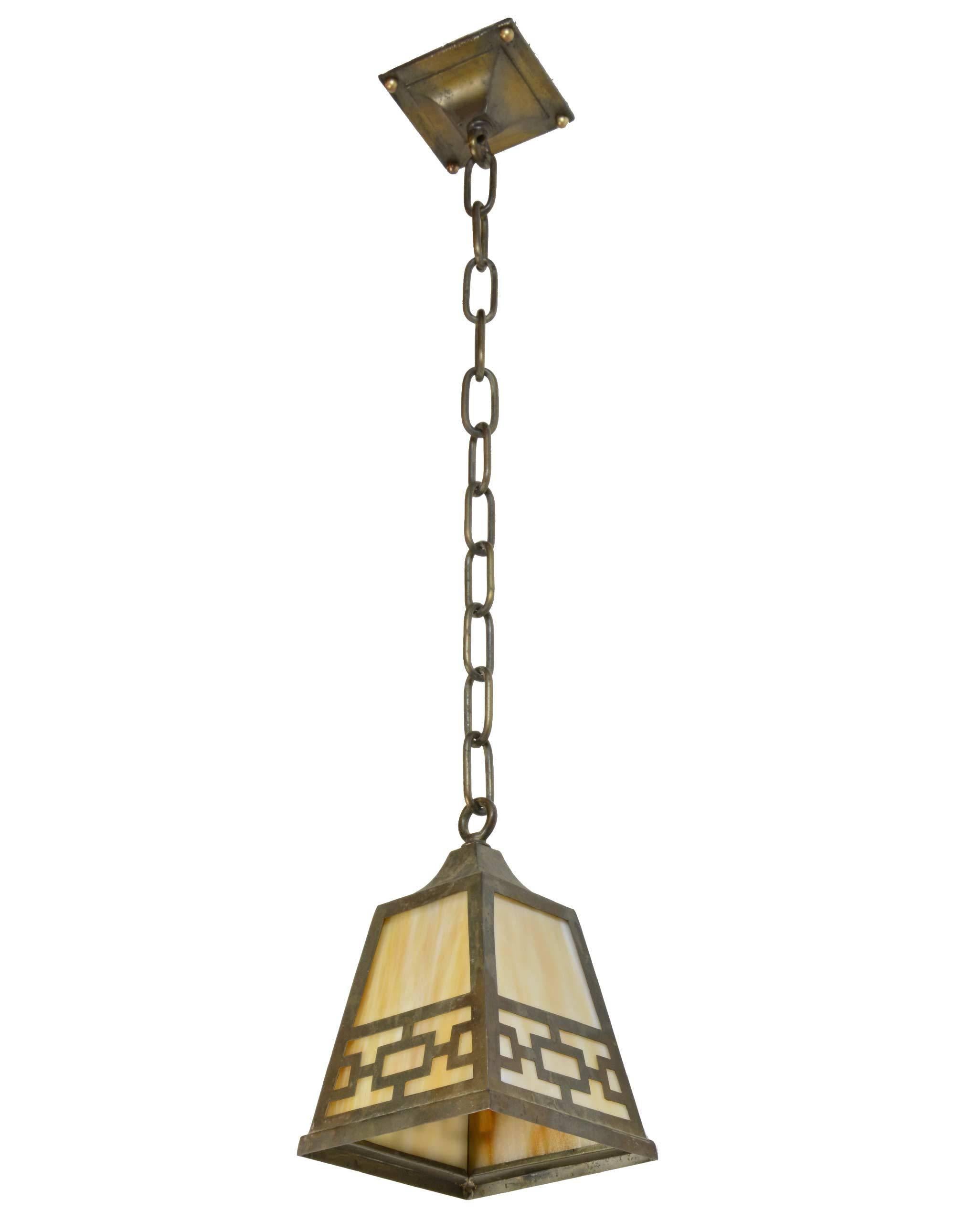This quaint brass mission style pendant has a tapered square shade with amber slag glass panels and it's original canopy and chain,

circa 1915.
Finish: Original
Country of origin: USA
Single medium socket.

Measures: 29