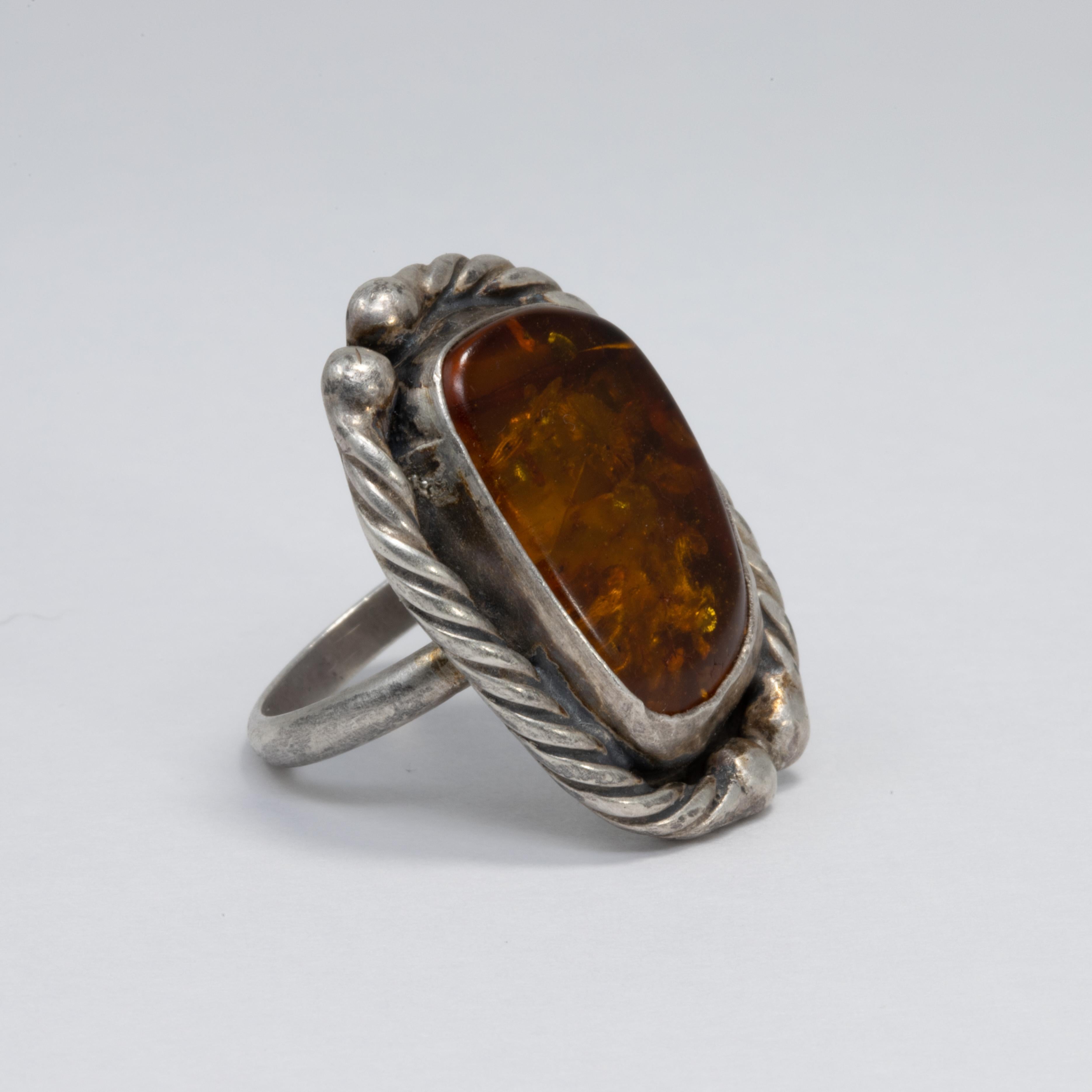 Exquisite sterling silver statement ring with an amber cabochon set in a decorative bezel.

Ring size US 7

Marks / hallmarks / etc: 8yan Sterling