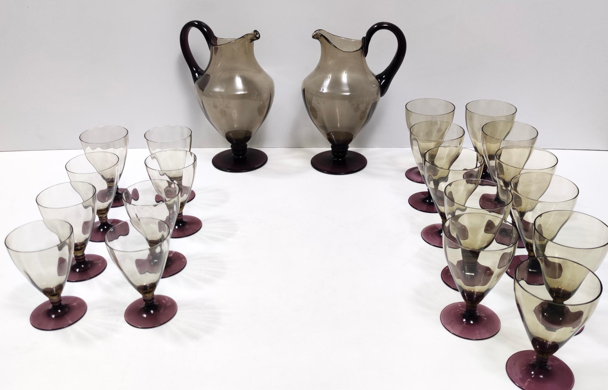 Made in Italy, 1920s.
Made in Murano glass. 
This set has two pitchers, 11 water glasses and 11 wine glasses.
It is a vintage set, therefore it might show slight traces of use, but it can be considered as in excellent original condition and ready