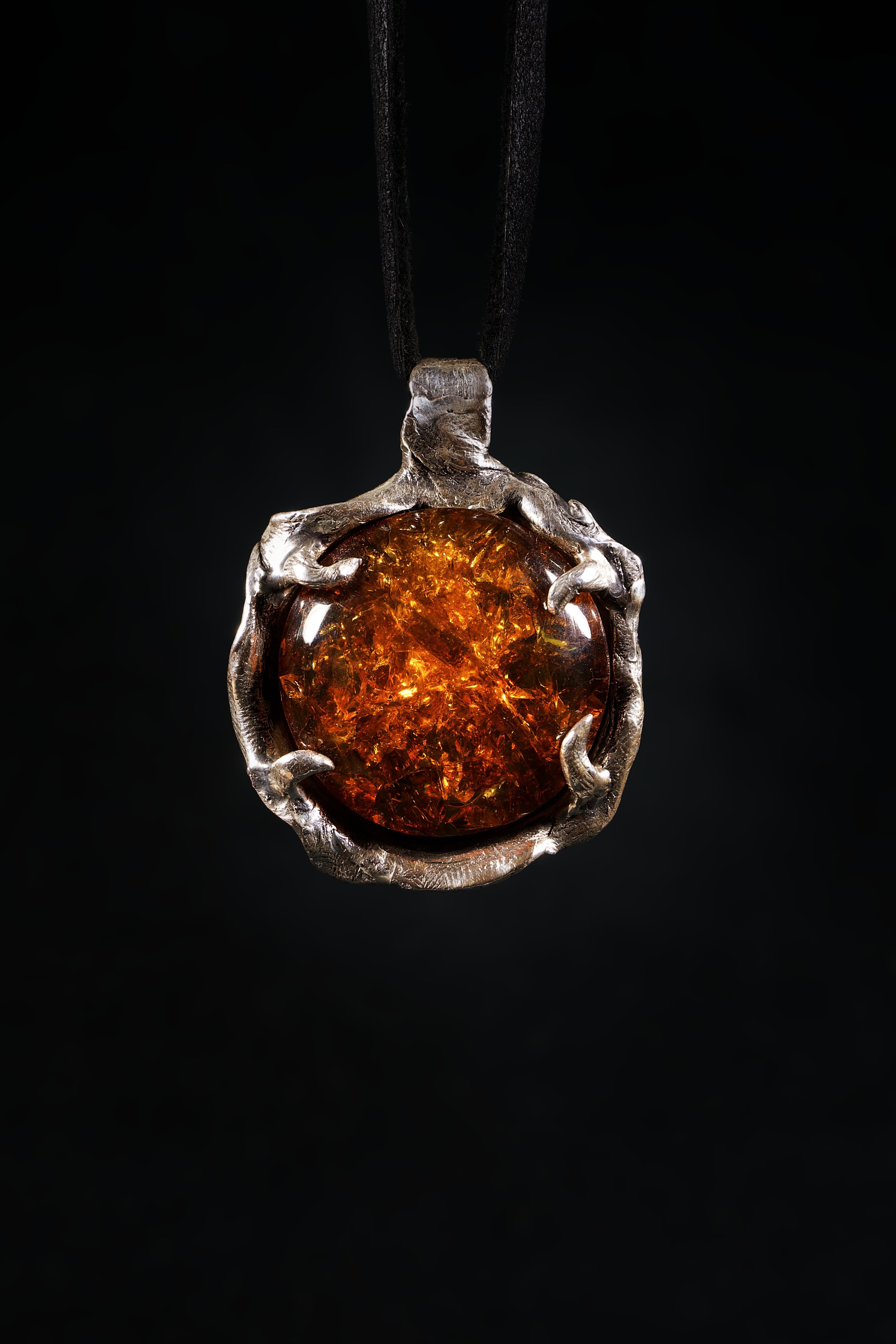 This pendant is a one-of-a-kind piece by Ken Fury that is hand carved and cast in sterling silver with a natural Mexican amber stone.

Stones: Natural Mexican amber

Metals: Sterling silver.

Hand-signed.

Size of piece: 54mm x 40mm

Size of stone: