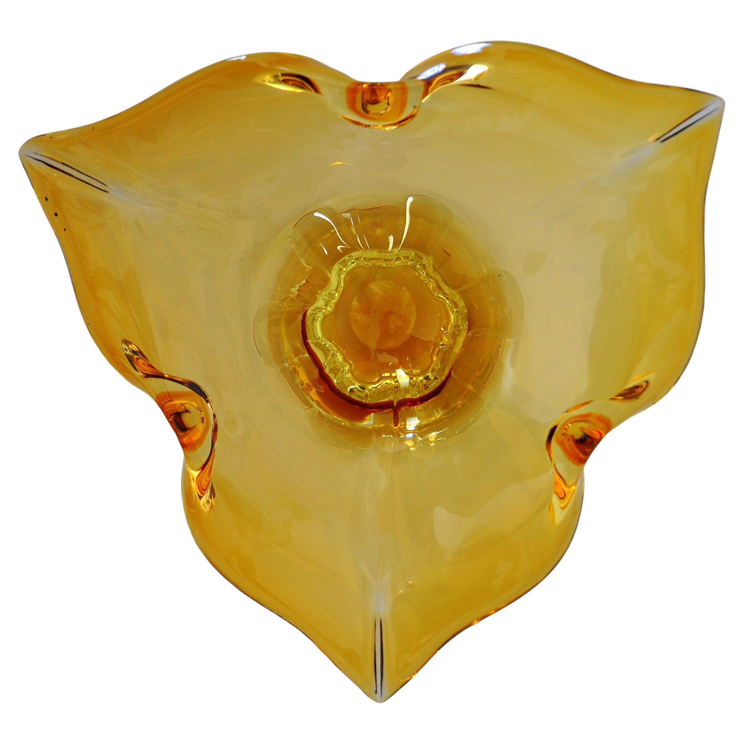 Ciotola decorativa con piede in vetro di Murano giallo ambrato vintage, facilmente utilizzabile come contenitore o centrotavola per frutta o potpourri. Vetro veneziano soffiato a mano con rientranze e svasature che creano una forma floreale