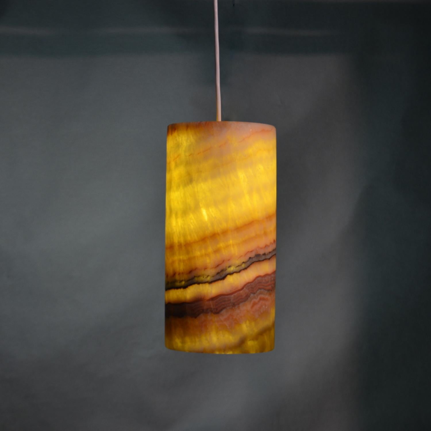 Cylinder rainbow ceiling lamp in onyx. Beautifully handcrafted lamp from yellow/orange/red striped onyx.