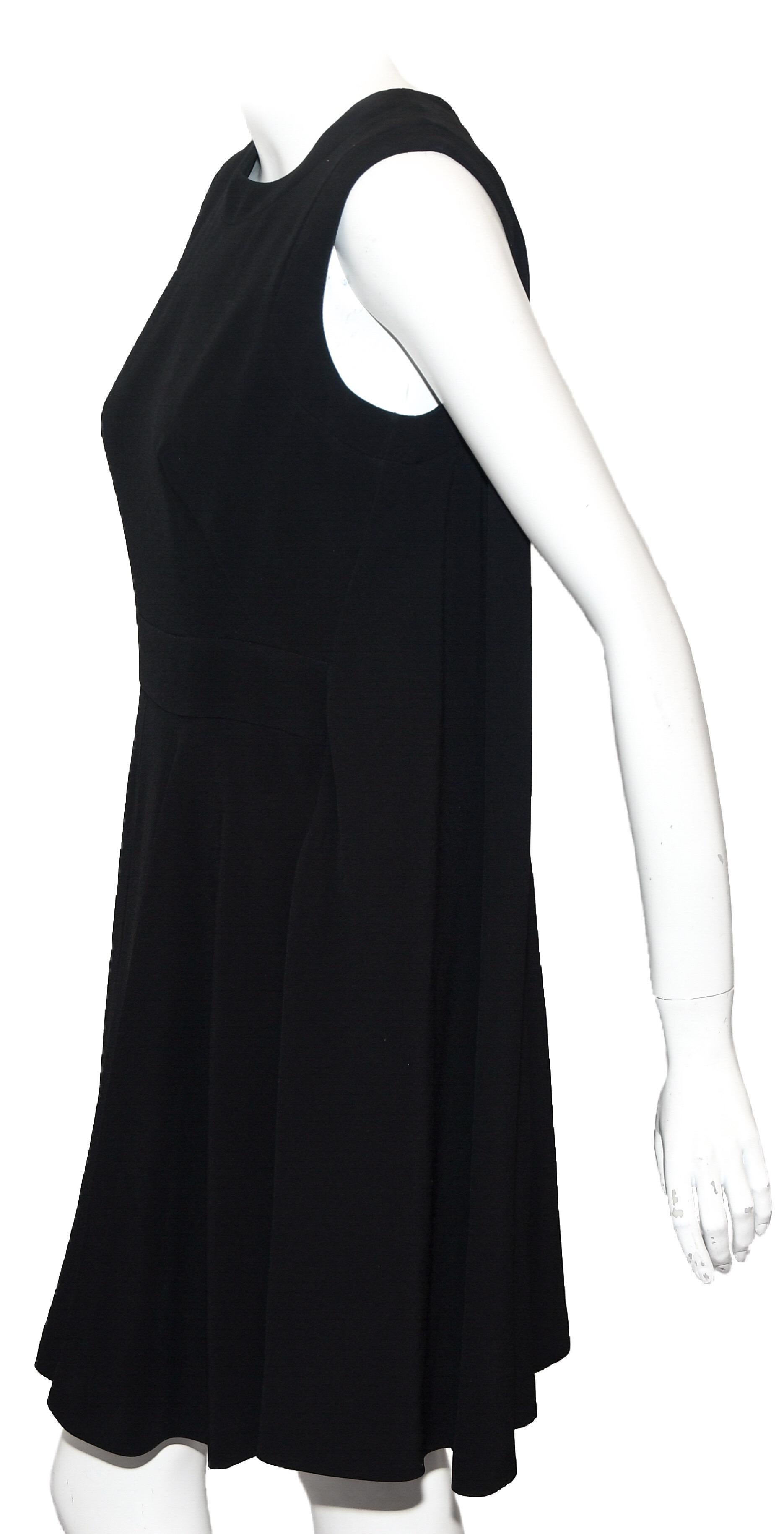 Alexander McQueen black sleeveless paneled dress is loose fitting and evokes the trapeze dresses of the 1960s.  Silk dress features round collar, pleated skirt, 2 panels on each side, and hidden rear zipper with hook and eye closure.  Large, rear