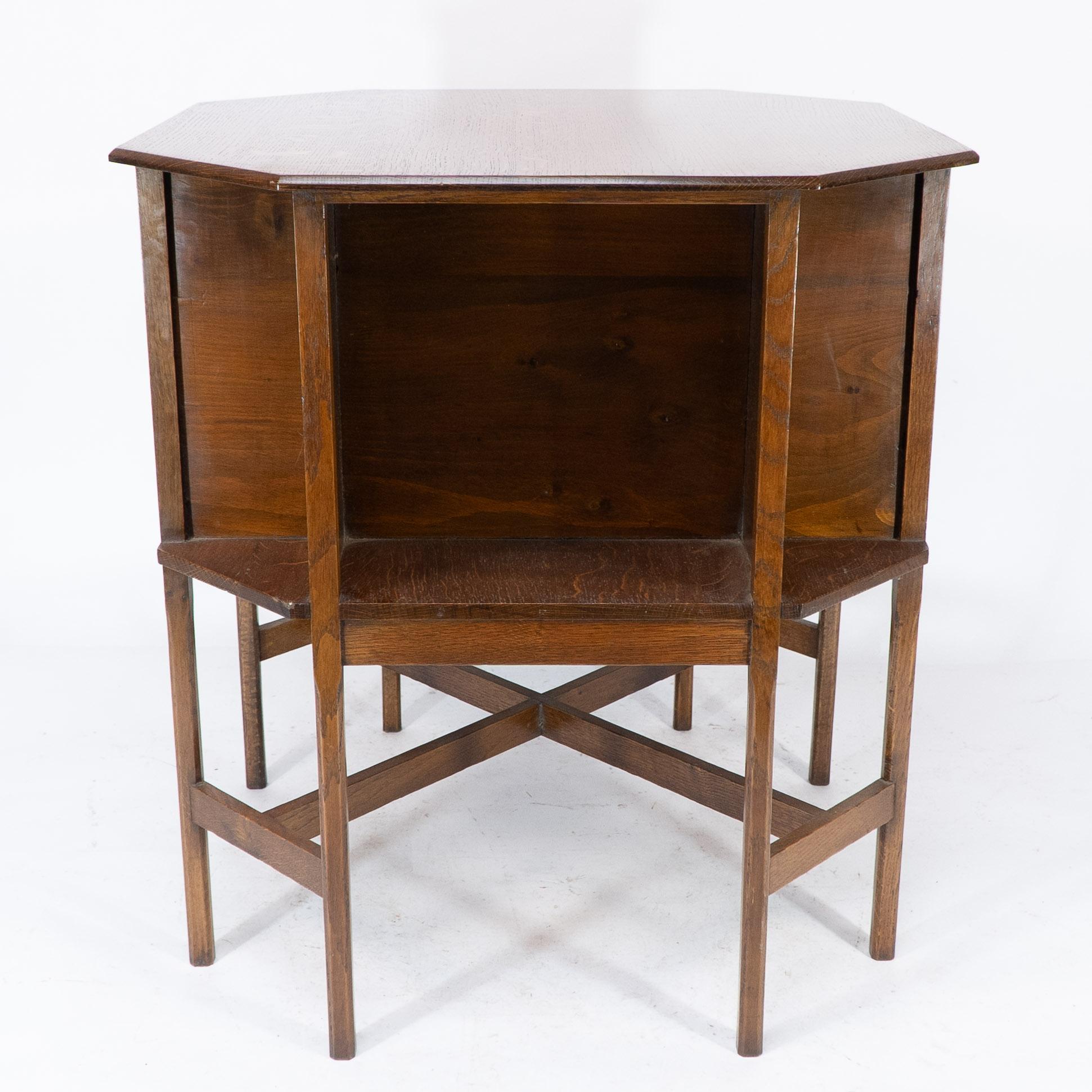 Ambrose Heals attributed.
A well designed Arts and Crafts oak octagonal book/side table with compartments below stood on eight chamfered legs and well executed cross stretcher arrangement ending with precision tenon joints uniting the legs.