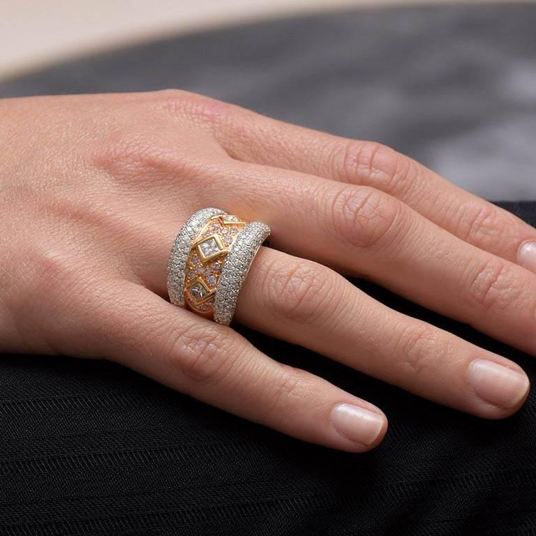 Dieser in Handarbeit aus 18 Karat Rosé- und Weißgold gefertigte Ring im Ambrosi-Design weist drei in die Lünette gefasste Diamanten im Princess-Schliff von insgesamt 0,60 Karat auf, die von gepflasterten rosa Diamanten von insgesamt 0,41 Karat und