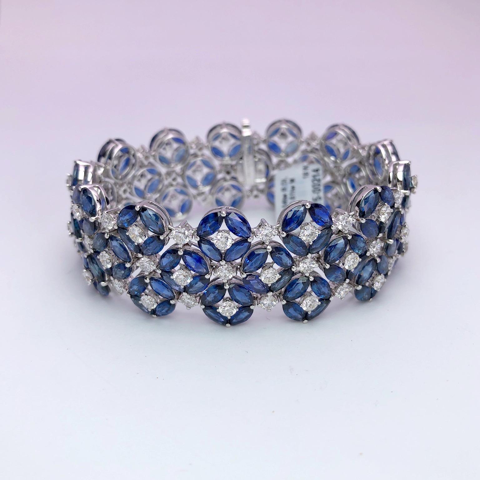 Magnificent 18 karat white gold bracelet. This bracelet is uniquely set with 3 rows of marquise cut blue sapphires and round brilliant diamonds. Four marquise sapphires with a round diamond center form a flower, each is joined together with a round