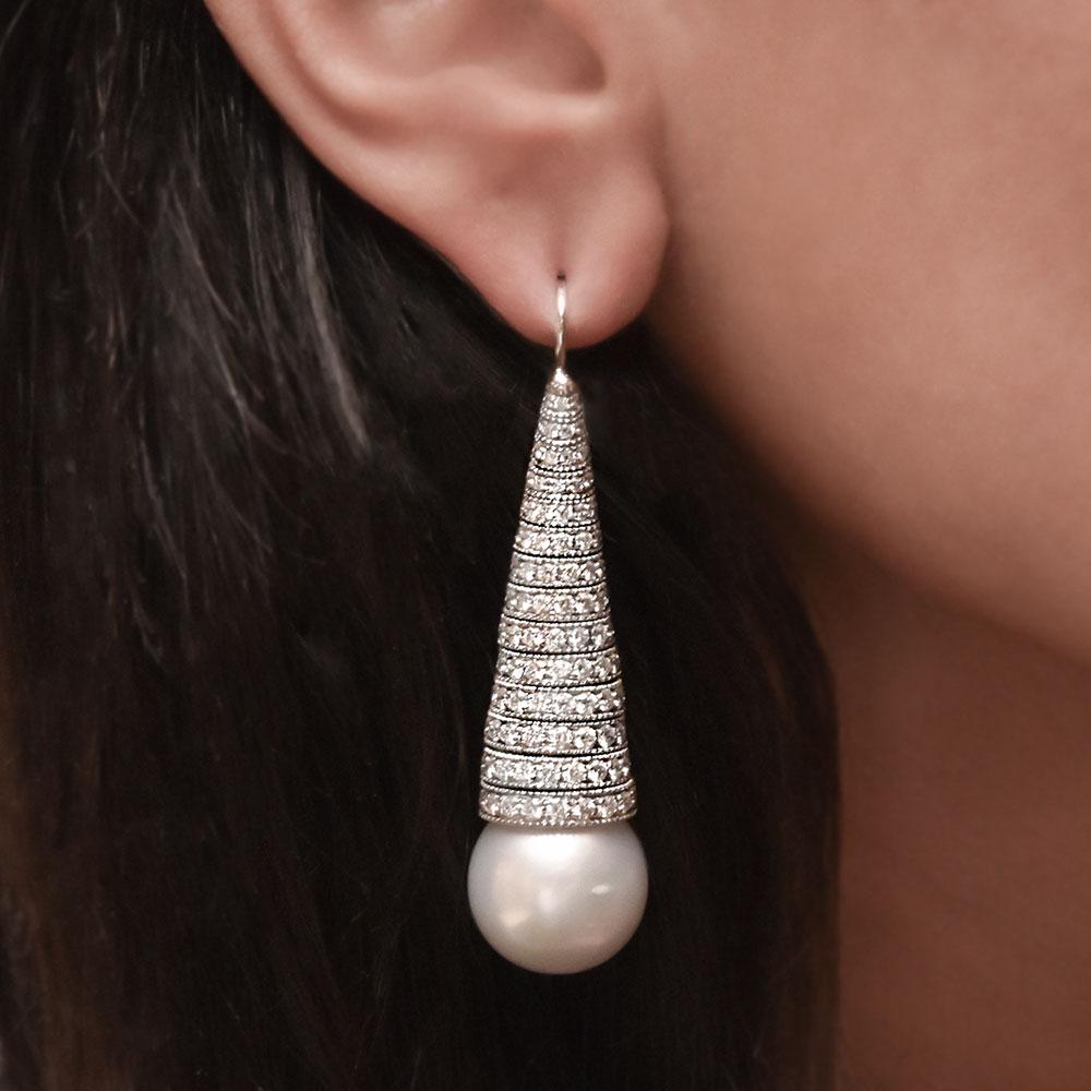 These beautiful hand crafted earrings are composed of two 15x16mm SouthSea Pearls which hang from a swirl of round brilliant cut diamonds.  The cone shape is fully articulated, allowing for easy beautiful movement. 
6.48 carats of diamonds. 
Set in