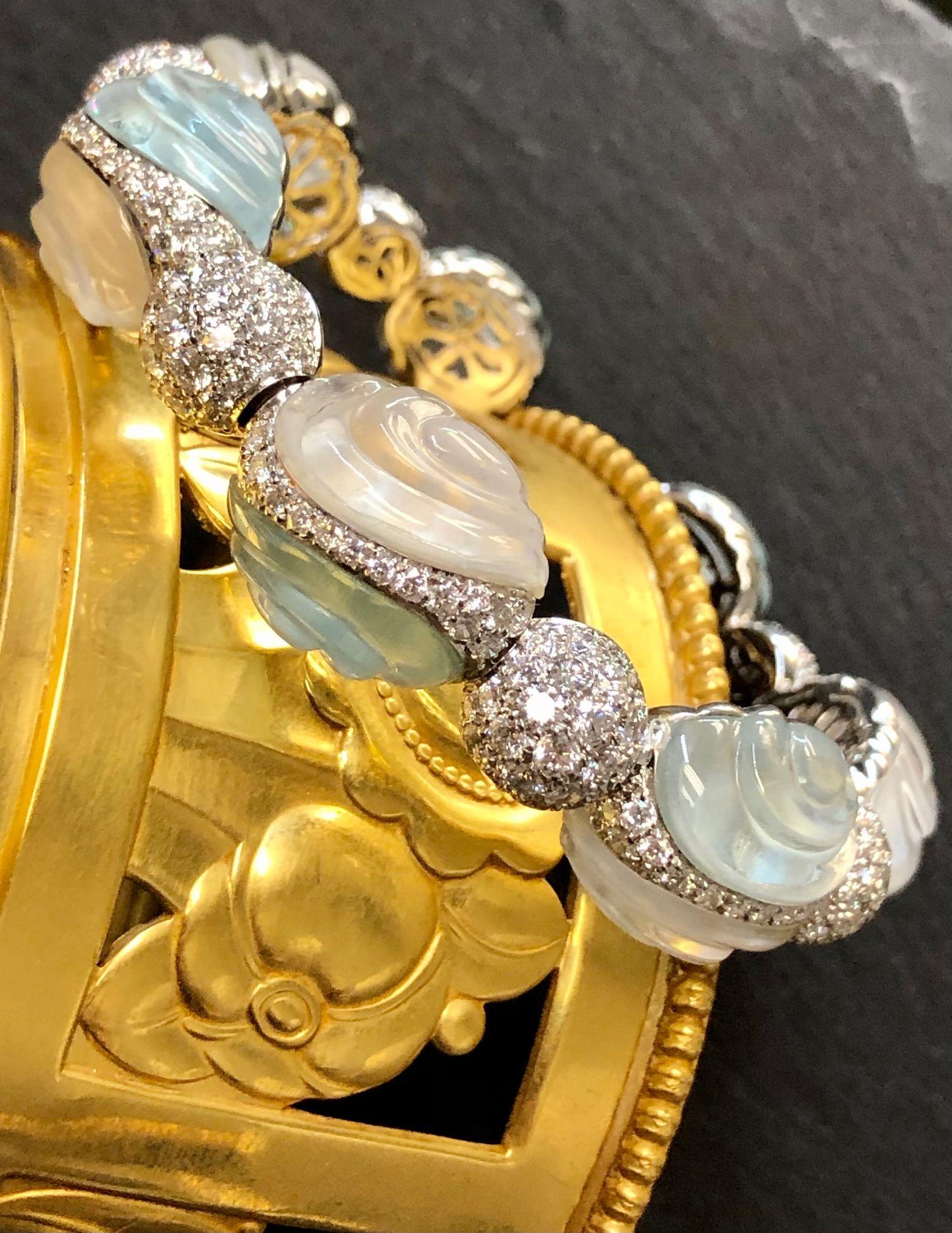Gorgeous bangle done by Italian designer AMBROSI from their BON BON collection in 18K white gold with carved natural aquamrine and quartz as well as approximately 10.60cttw in F-G color Vs1-2 clarity diamonds.

Dimensions/Weight
.60” wide and fits a