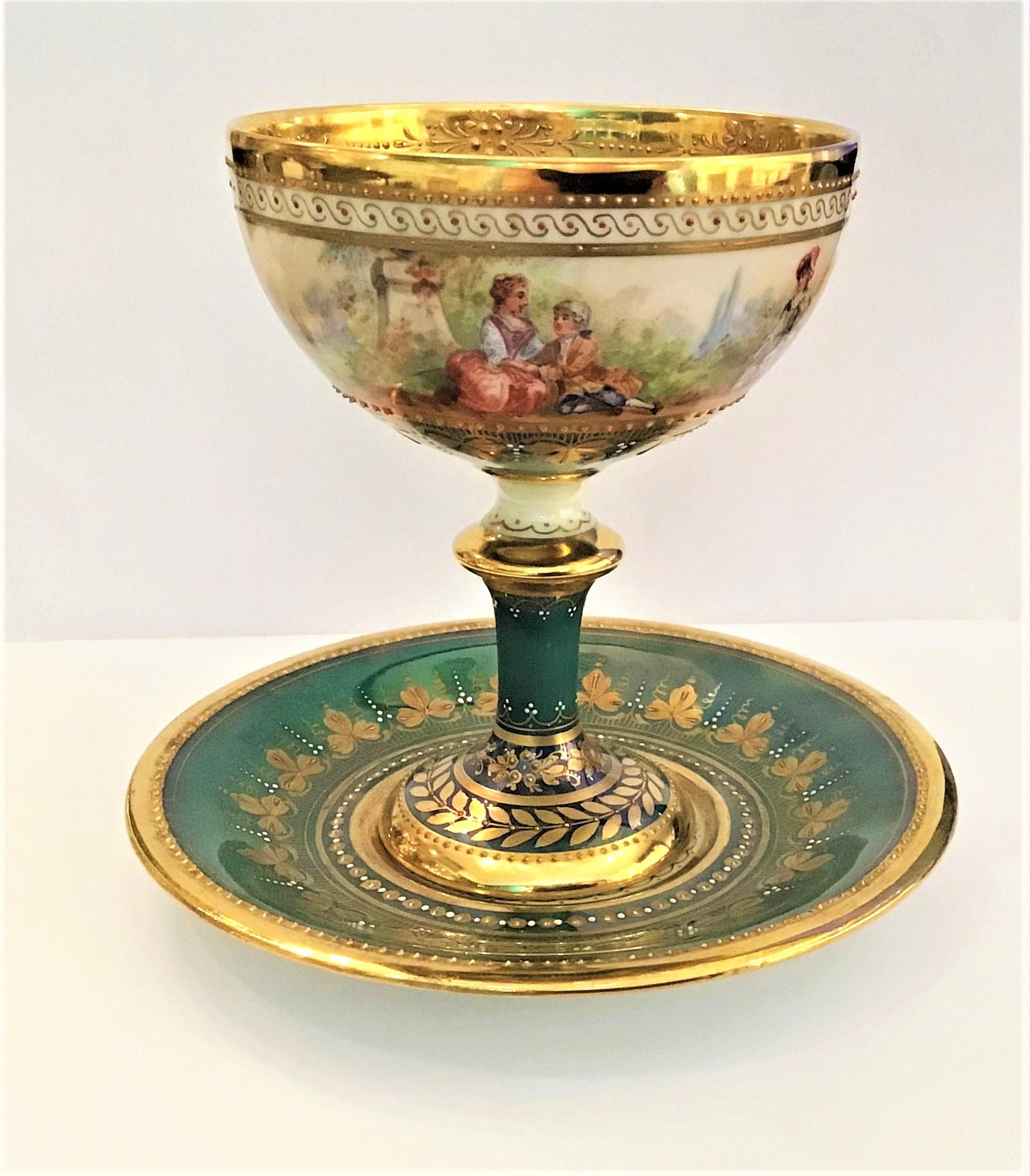 Amazing Dresden Ambrosius Lamm Luster green courting couple hand painted pedestal cup and saucer, circa 1910.

Magnificent porcelain pedestal cup and saucer with panoramic painting of courting scenes and raised gold decoration inside the cup.