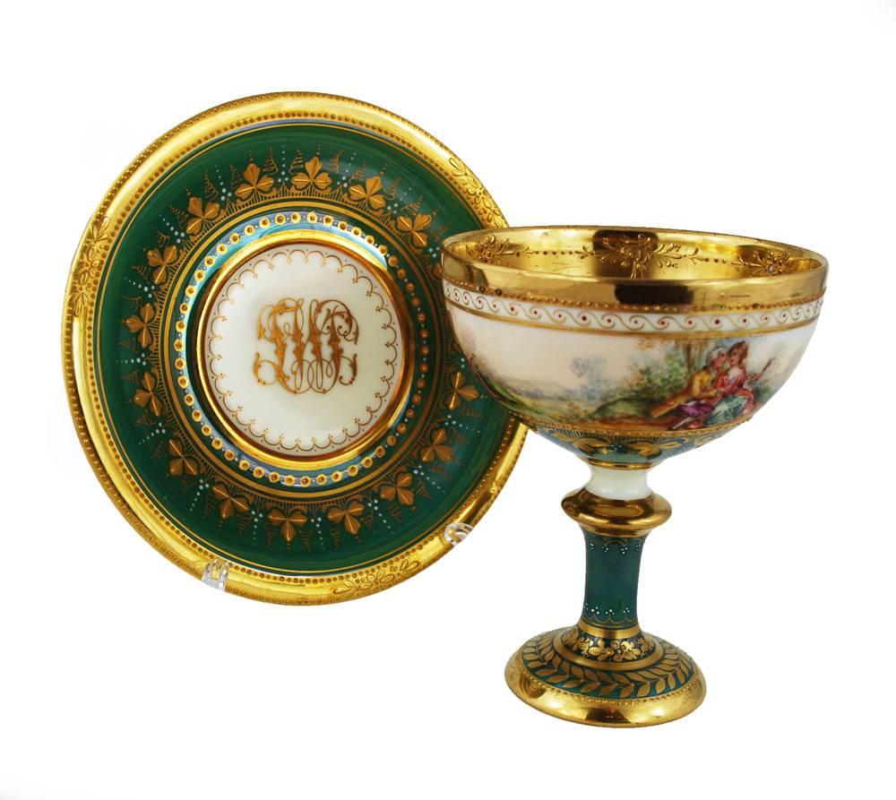 Cup has a hairline

A lovely hand painted footed cup and saucer from Ambrosius Lamm Studio in Dresden, featuring romantic era scenes of courtship, circa 1930. Heavily gilded, including raised gold paste, the cup is very refined with high quality