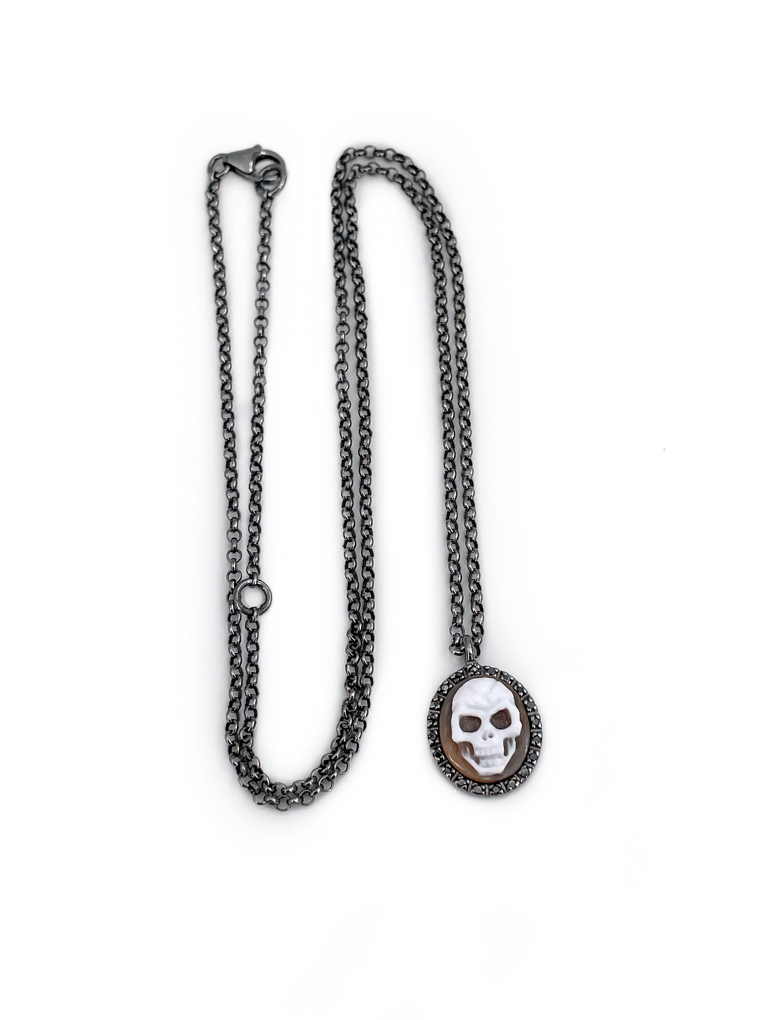 This is an exclusive design pendant necklace designed by Italian jewellery brand Amedeo in 2010s. It is crafted in 925 hallmark blackened silver. The piece features mini shell cameo depicting the skull. It is surrounded with 20 brilliant cut black