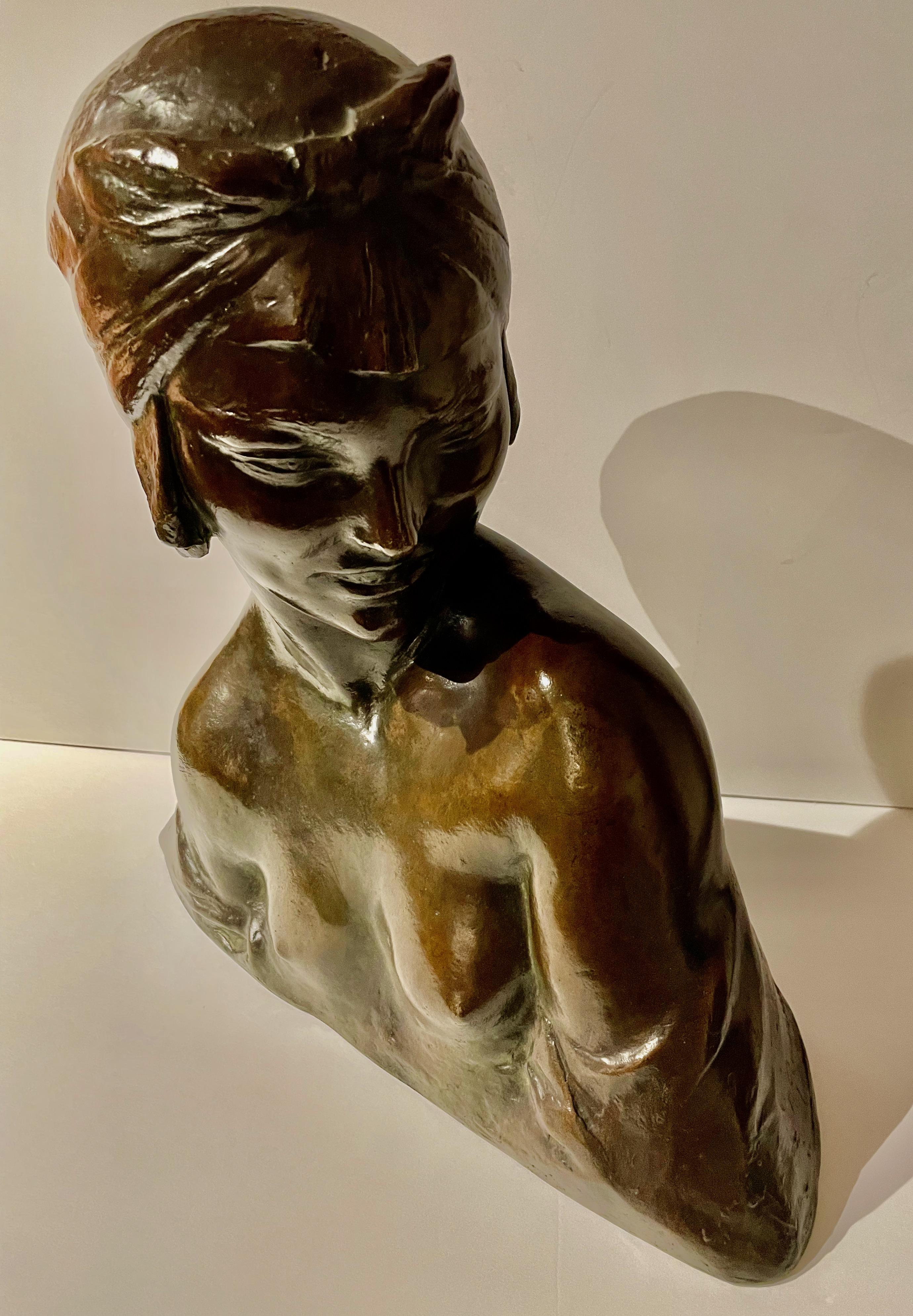An original patinated bronze bust by Amedeo Gennarelli, circa 1925. This slightly nude model is depicted from her shoulder looking forward with a stylized turban on her head. a stunning deep bronze patina signed in the cast ‘A.Genneralli’. The model