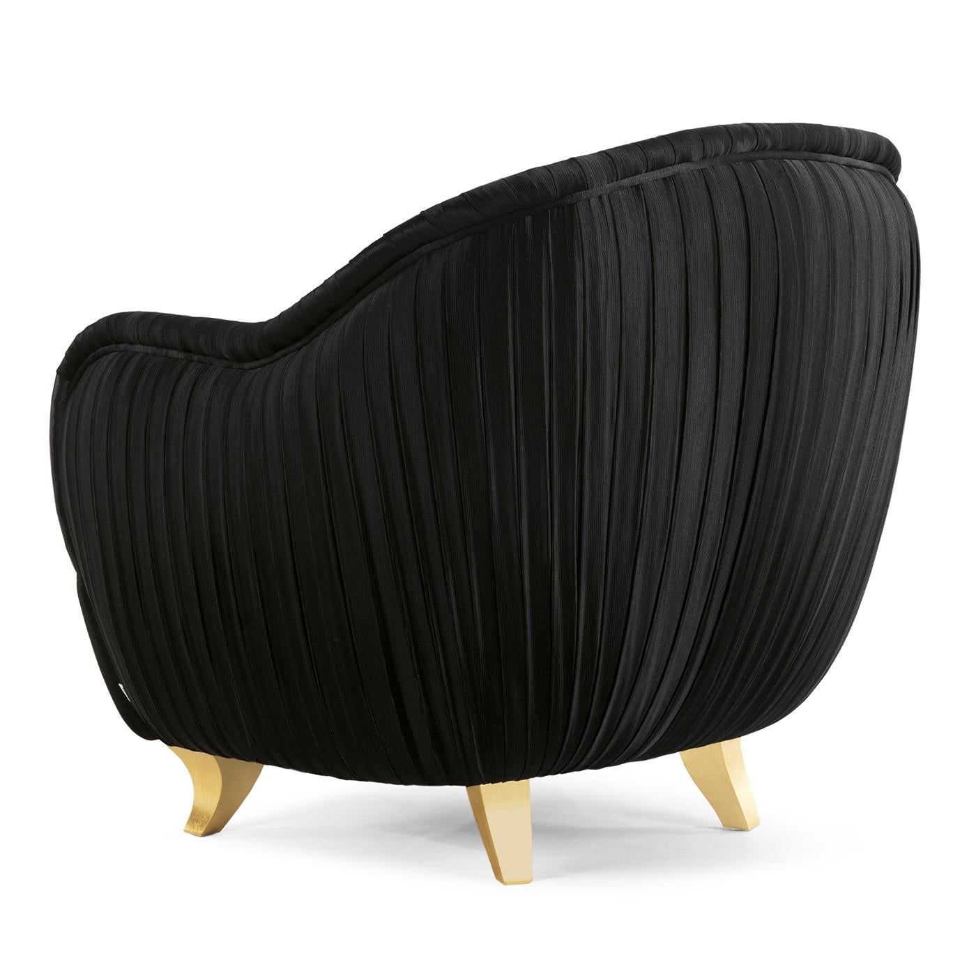A stunning piece of functional decor, this armchair combines comfort with an elegant design and features an exquisite upholstery in fabric that was pleated by hand throughout, making it ideal to be displayed also in the center of a room. Its frame