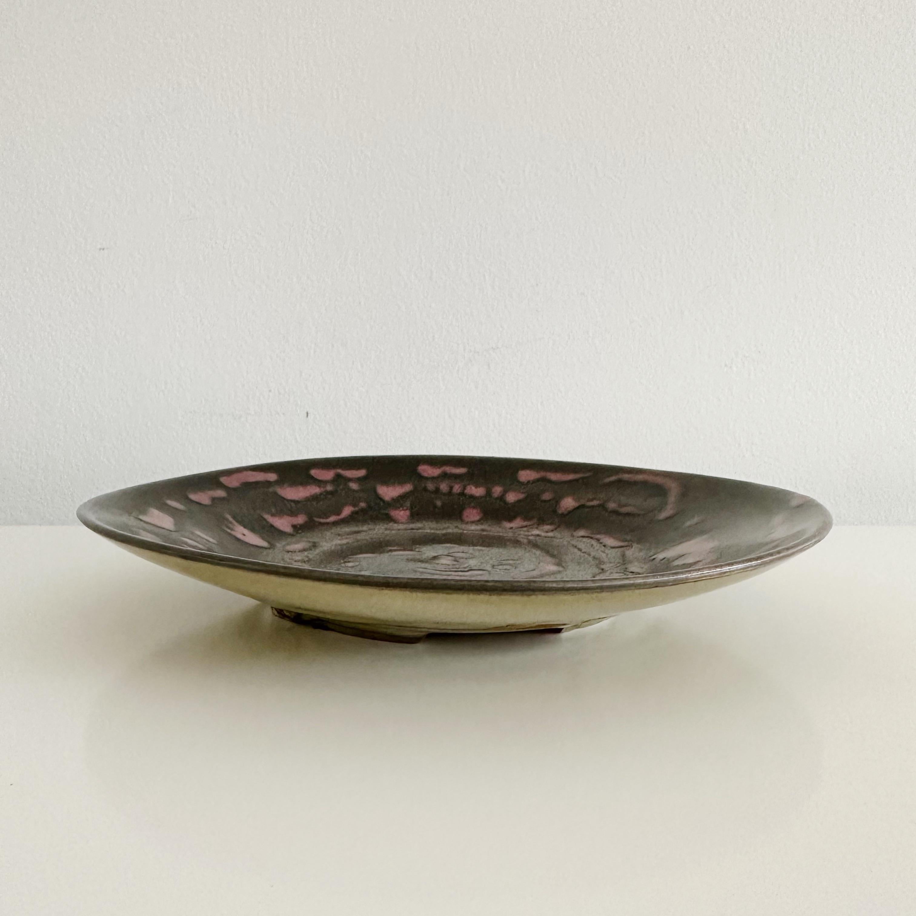 Hand made glazed studio pottery shallow bowl or plate by Amelie (Amely, Aly) Richter, in plum, lavender and black ues. Signed Aly Richter on underside.

Before her marriage to Dr Georg Martin Richter, in November of 1920, naturalised American