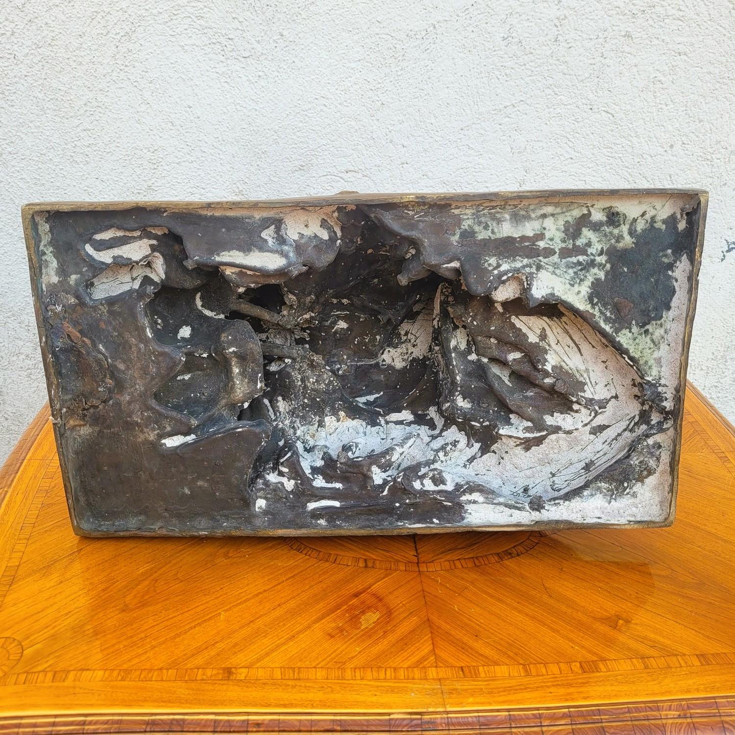 Grande scultura in bronzo con patina marrone, che rappresenta una donna nuda, seduta in poltrona, con una matita in una mano e un vaso nell'altra, circondata da oggetti d'antiquariato.  

Firma dell'artista GB Amendola in un'anfora sul retro della