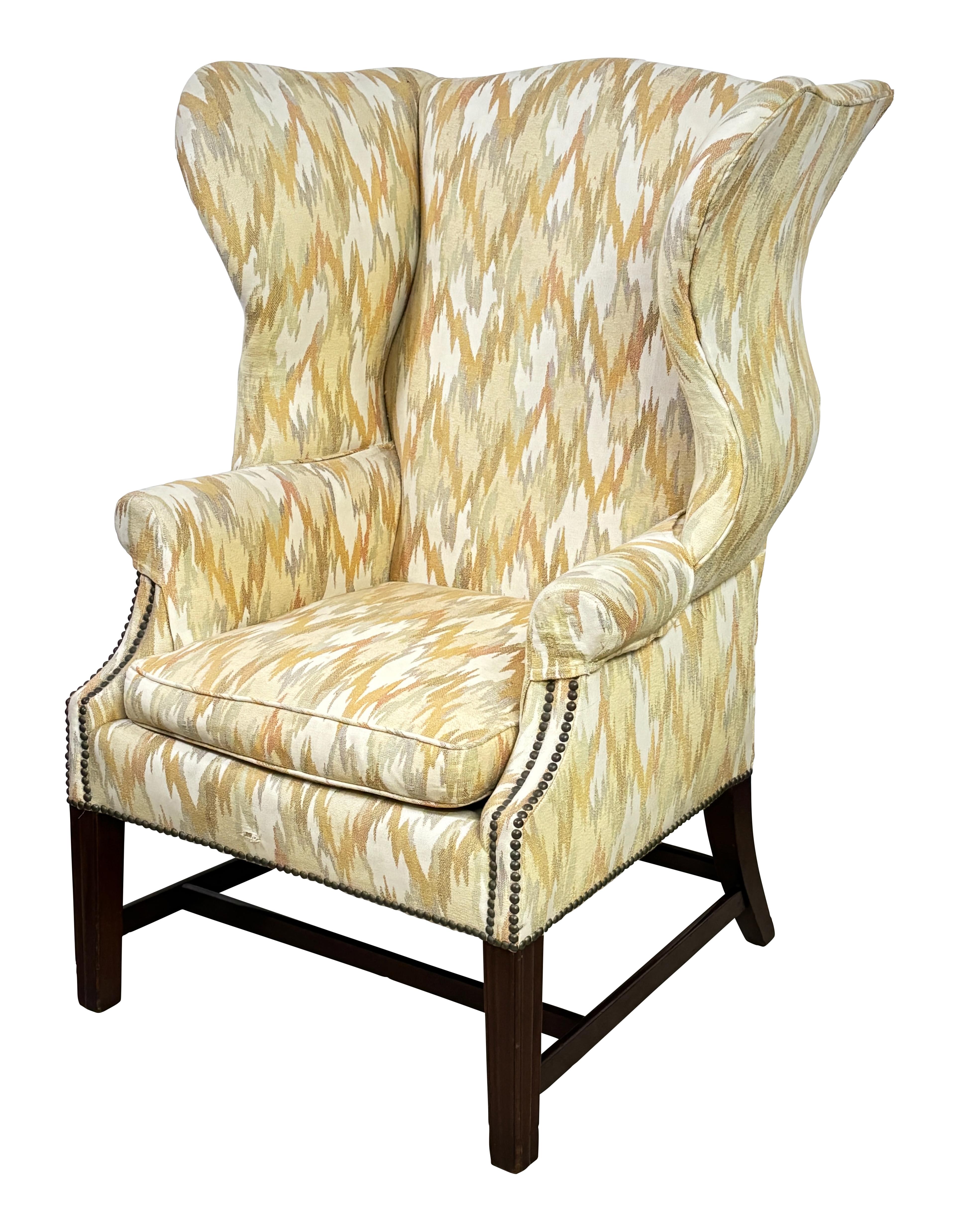 An early 19th century (possibly late 18th century) American Wingback style Gentleman's Chair. Sturdy and sound with a nice generous seat. 
In need of new upholstery. When this chair was upholstered sometime in the 1970's springs were installed in