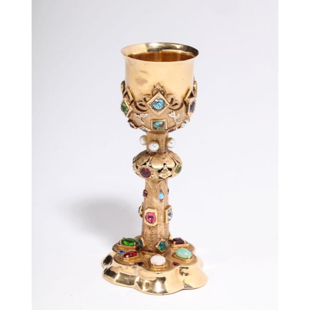 An American 14-karat yellow gold and semi precious stone miniature chalice cup, circa 1970.  

Polished and brushed 14-karat yellow gold set with pearls, opal, jade, diamonds, and colored gem stones.  

Measures: 4.5