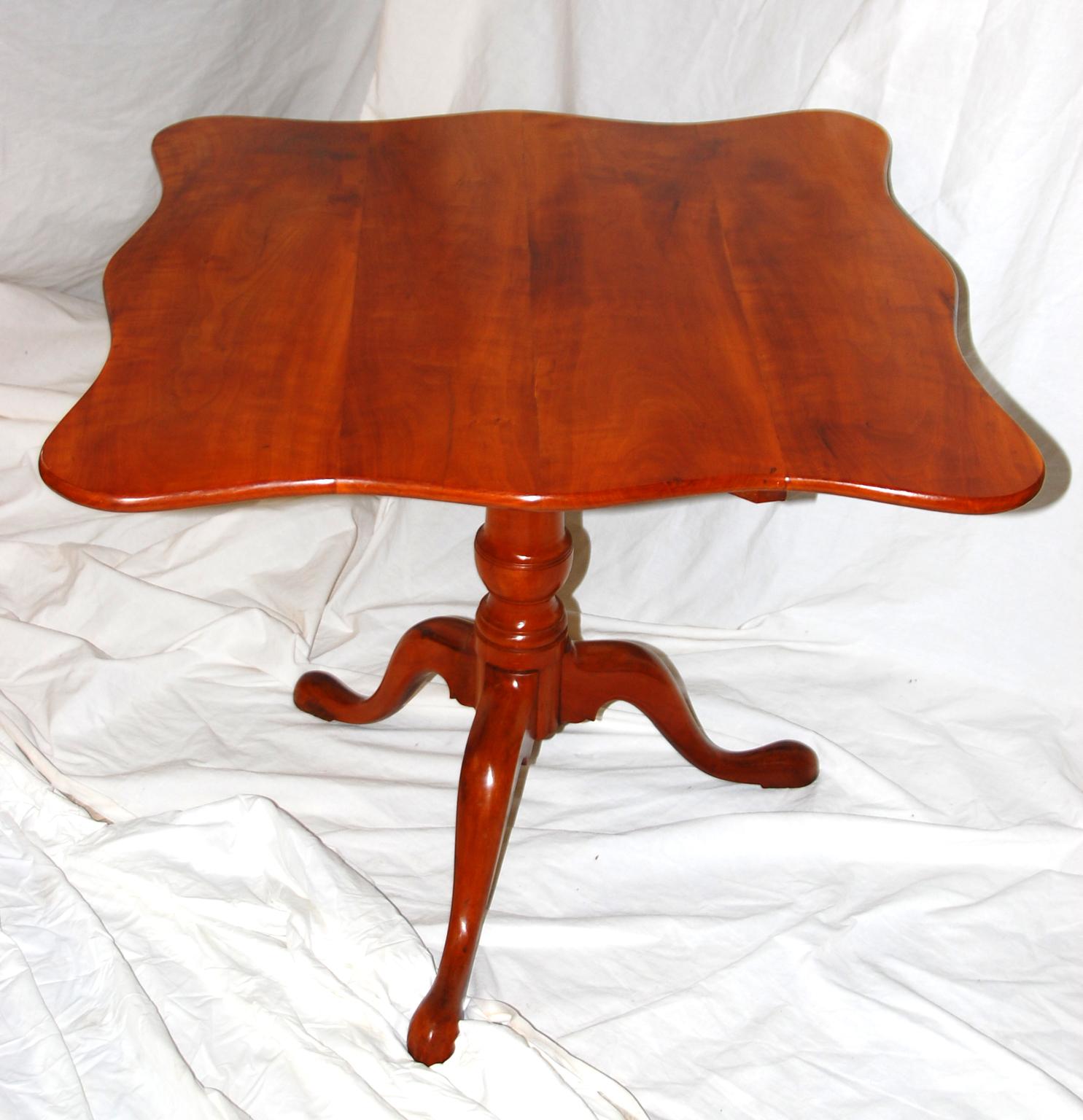American federal tripod tilt-top table in apple wood, probably of Connecticut origin. The graceful scalloped edge of the top and cabriole legs along with the well proportioned vase turned stem set this table apart from the more usual rectangular or