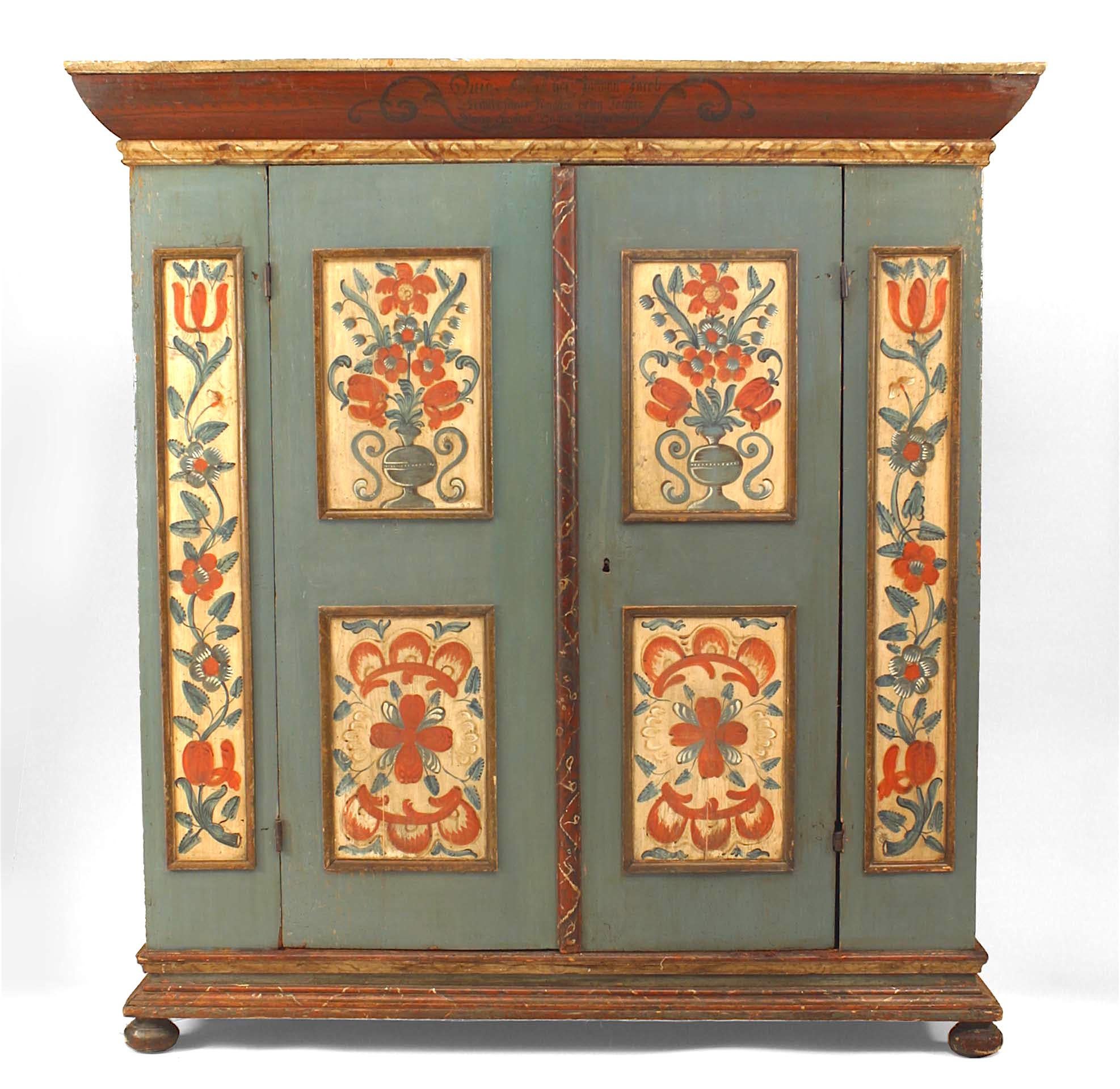 American German-Style (18th Century) blue/grey painted armoire Kas cabinet resting on bun feet with 2 large center doors and decorated with panels with a floral and vine motif
