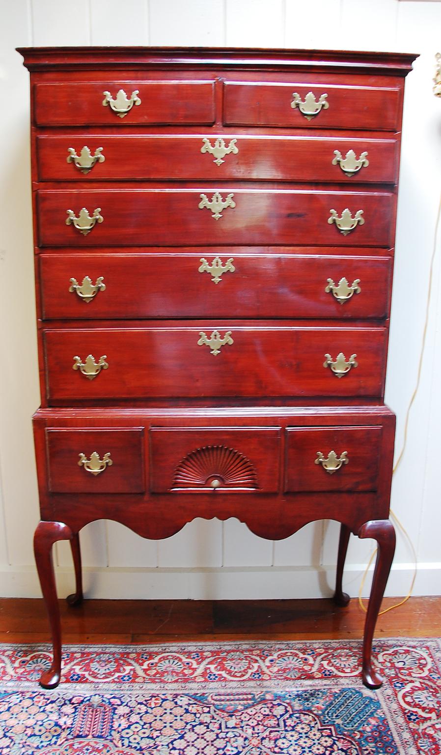 American Queen Anne maple highboy in two parts with cabriole legs, pad feet, fan carved central drawer and shaped skirt. This New England highboy is a classic with a flat top, molded cornice, elegant slender legs and edge molded drawers. The fan