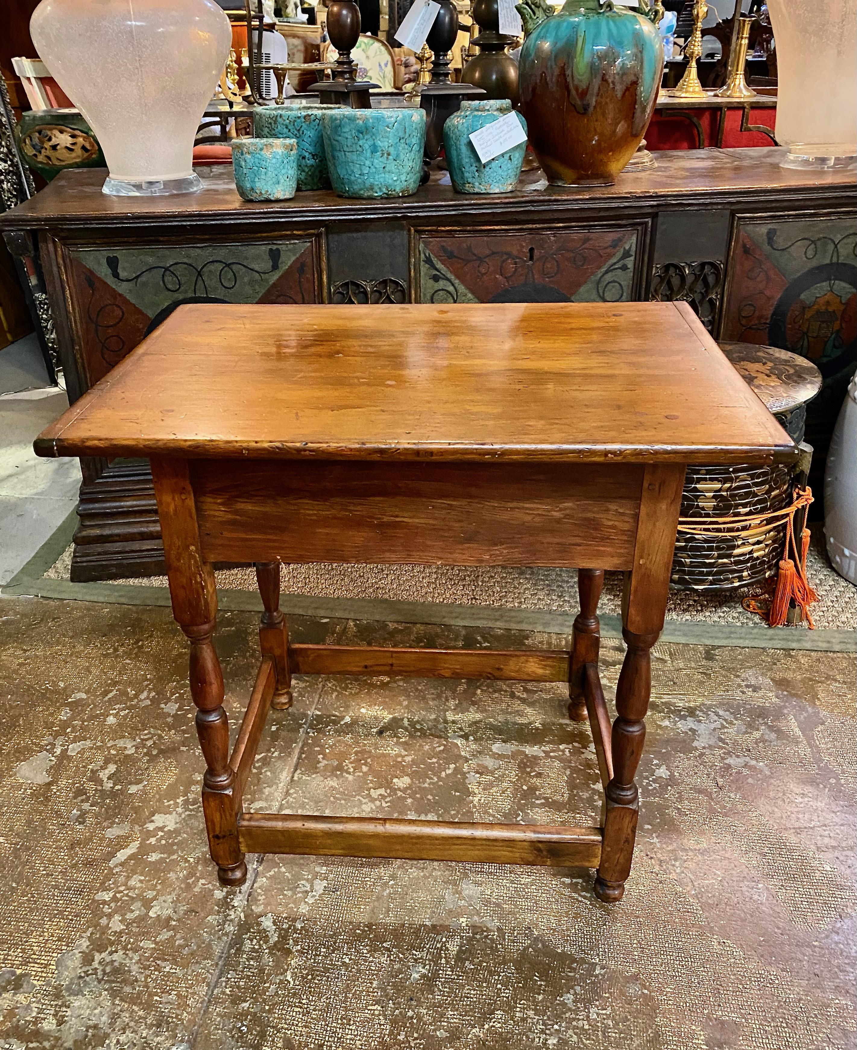 This is a charming New England small tavern table that dates to the latter part of the 18th century. The pine and maple table is in very good sturdy condition. It has an old surface and traces of the original black finish are present. The breadboard