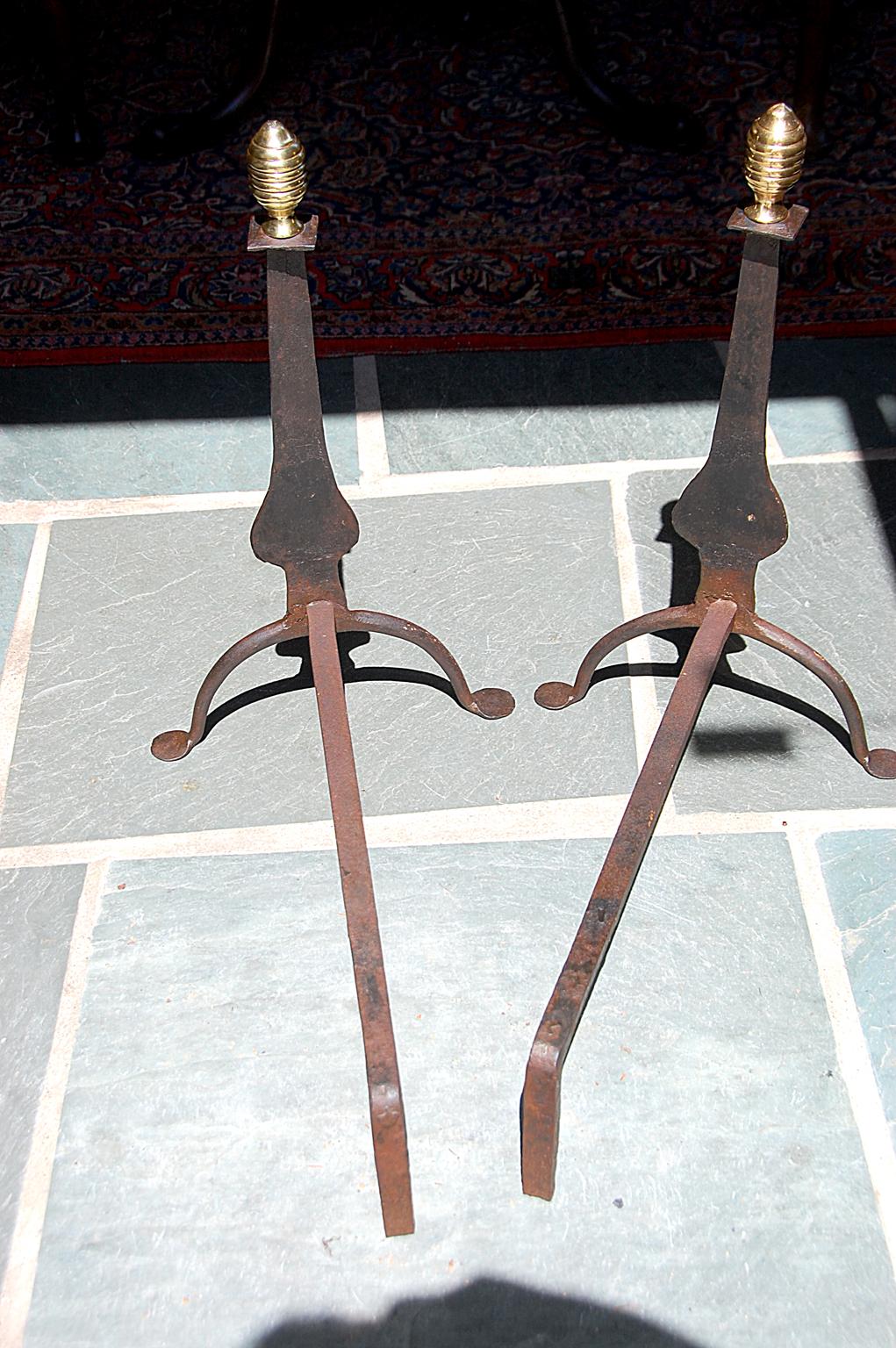 American 18th century pair of wrought iron knife blade andirons surmounted with cast brass beehive finials. These hand wrought 20 inch andirons exhibit the hammer marks which were integral to shaping these simple, yet elegant log holders. The cast