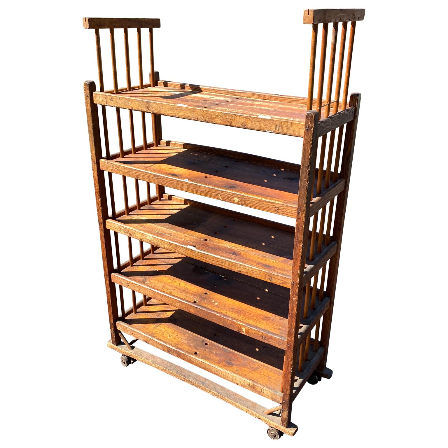 American 1930s wooden shelf, cart or bread rack on industrial iron wheels, with 5 shelves.
 