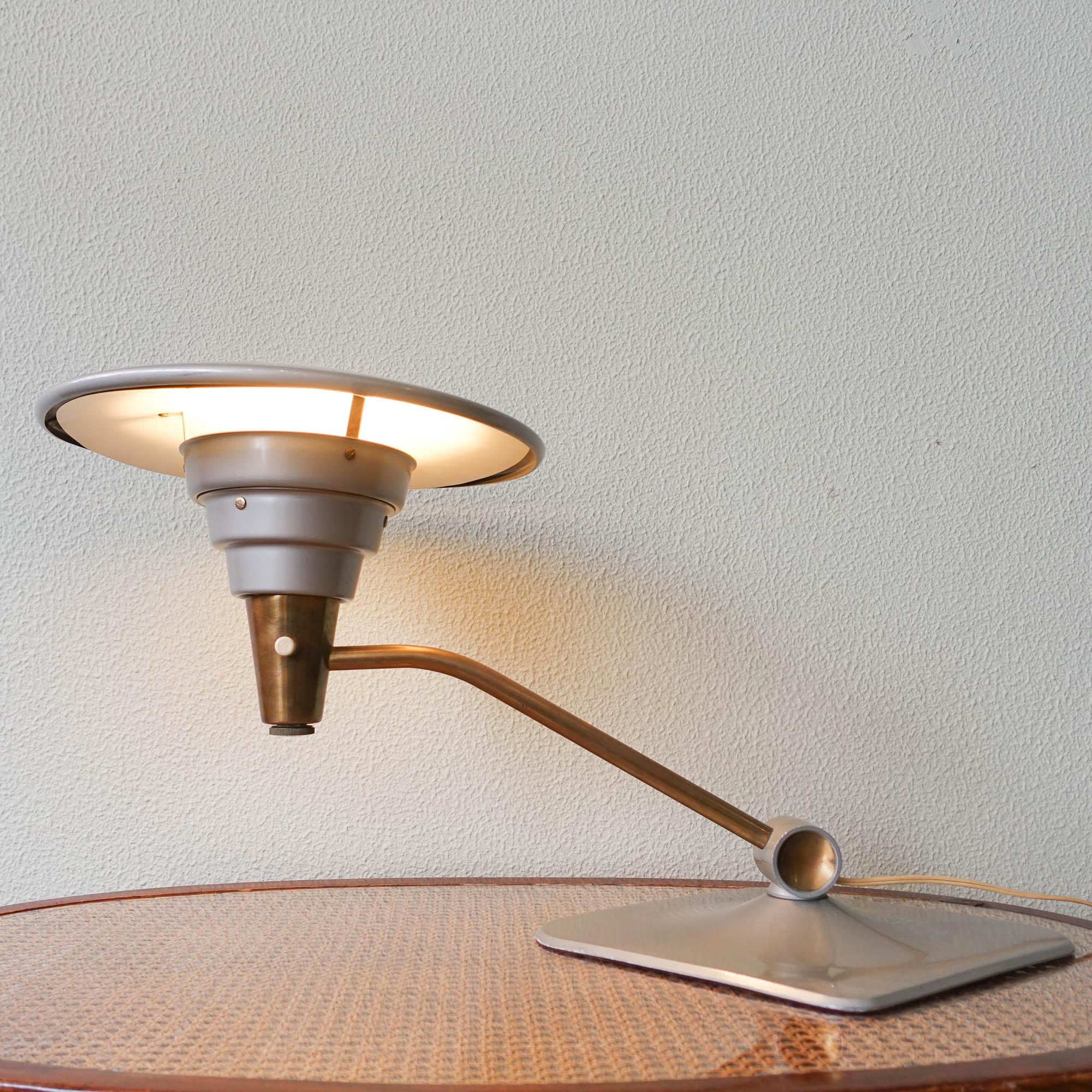 This table lamp, Model 1056, was designed and produced by Dazor Enterprise, in United States of America, during the 1950's. It is made of brass and anodized aluminum. Original factory label affixed to the underside of the shade.The stem can be