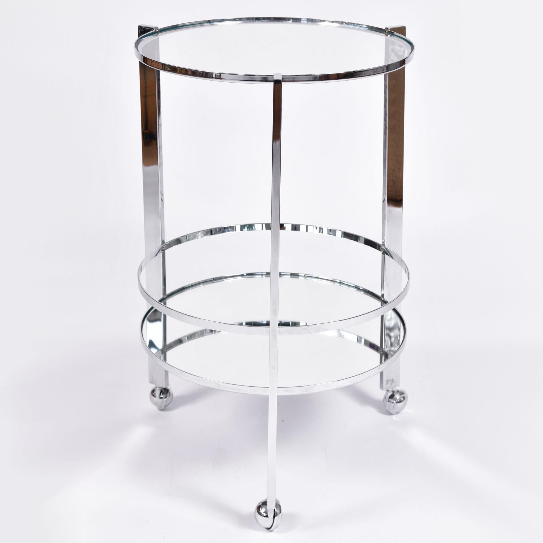 Two-tiered chrome circular drinks trolley/serving cart with chic modern frame. Mirrored glass bottom shelf adds beautiful reflection. Chrome covered caster wheels for smooth movement. Very good condition.
  