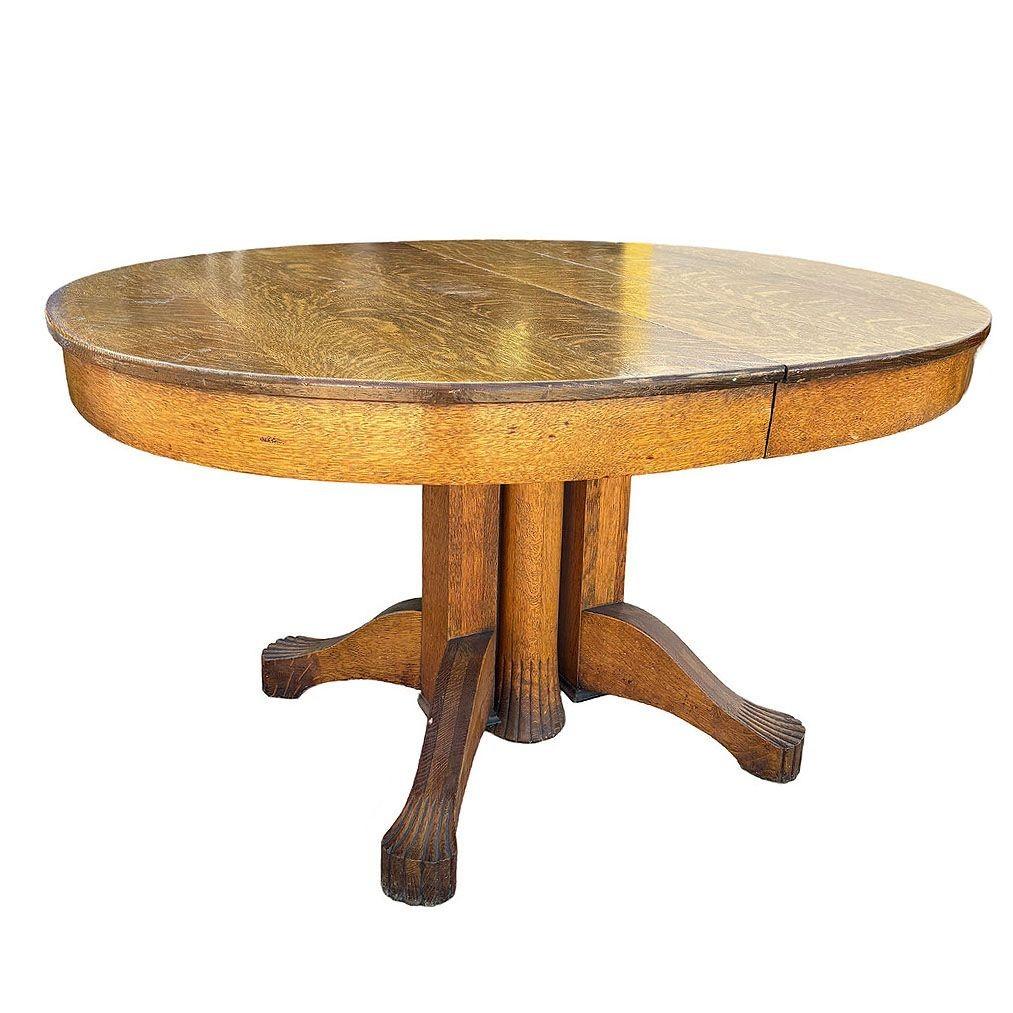 Late 19th century American Empire / Mission double pedestal dining table. Made from Quartersawn Oak. Features an extendable oval top over thick cylindrical pedestal bases with scrolled feet. The table's rich, warm finish and robust construction