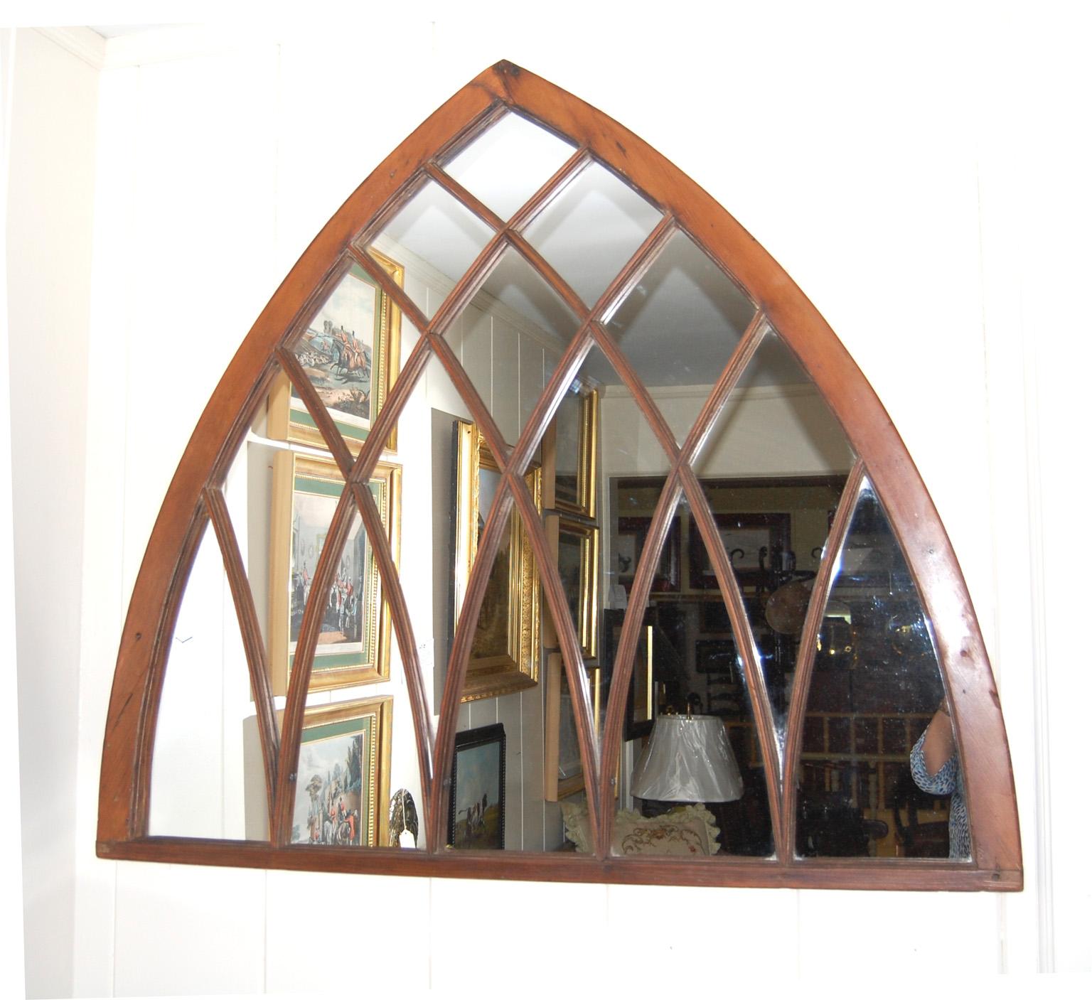 
 American 19th century pine large neo gothic arched window mirror with molded arched interlocking muntins.  This beautifully shaped window has had the window glass replaced with mirror, and the paint removed. The pine has a soft wax finish.     45