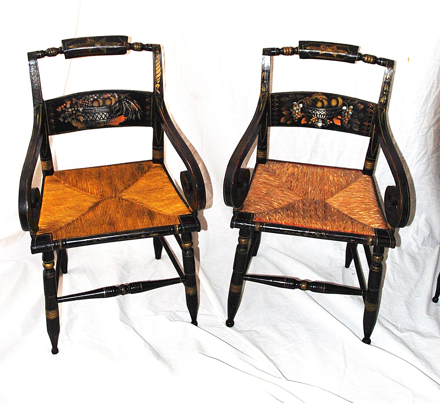 American set of eight Hitchcock 19th century chairs including two armchairs and six sidechairs. The armchairs have wonderful bold scroll arms. All eight chairs have stenciled backs of a basket of fruit and grains which sit on a black background. The