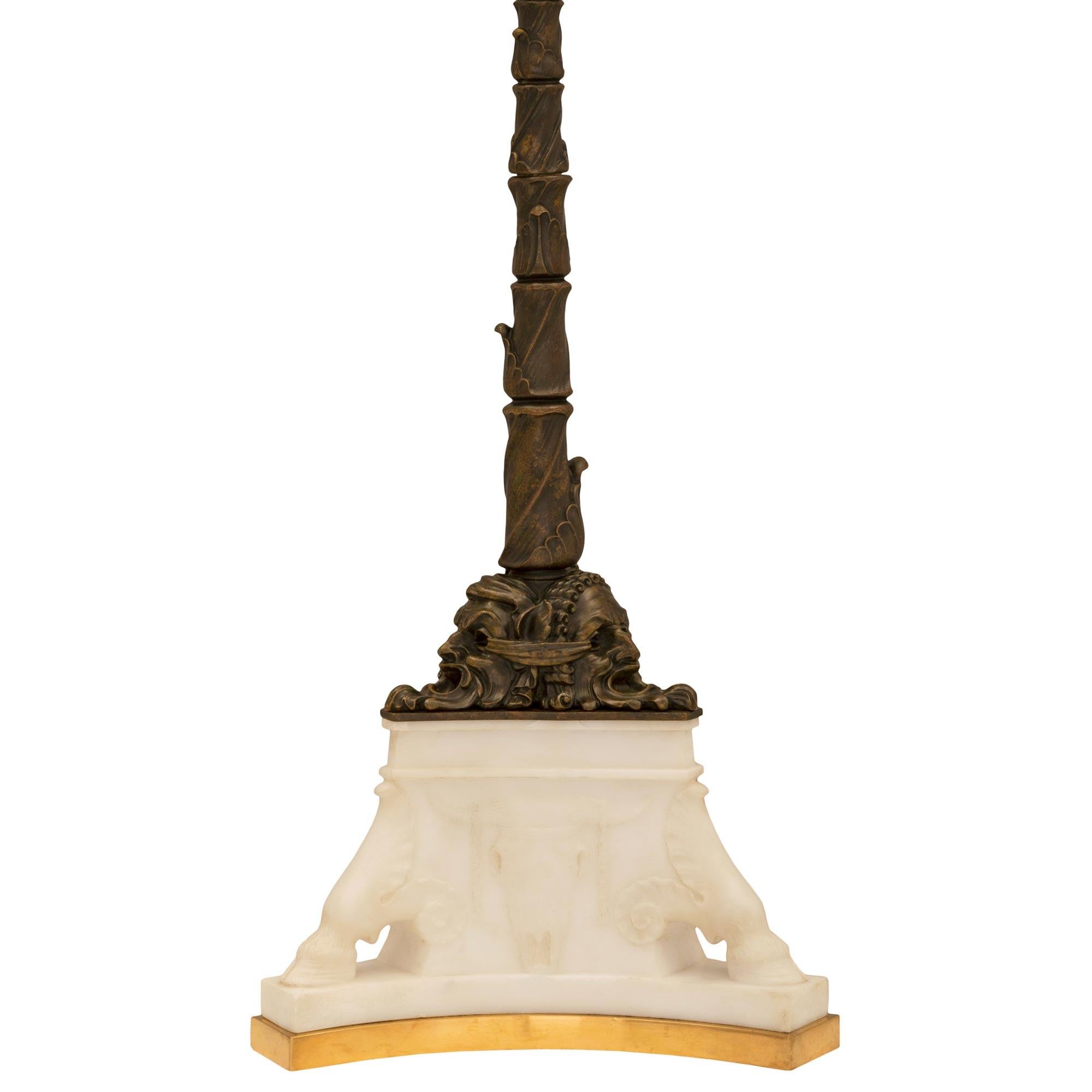 An impressive and unique American 19th century neo-classical st. ormolu, patinated bronze and white Carrara marble lamp signed Caldwell. The lamp is raised by a fine ormolu base with concave sides below the striking triangular shaped white Carrara