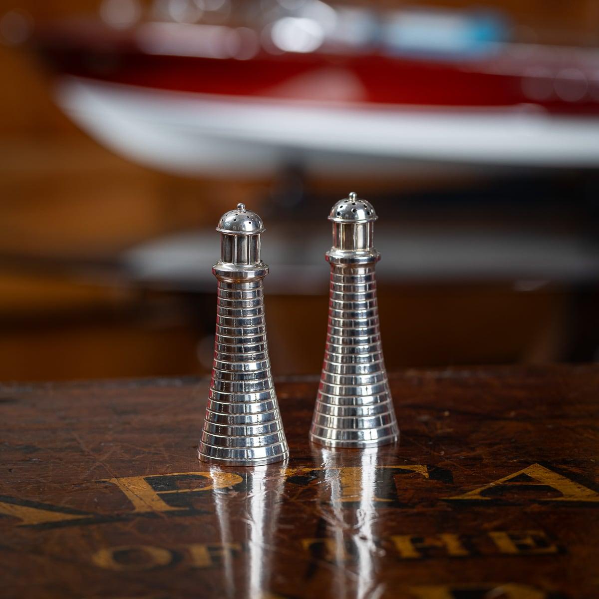 Un par de novedosas sales de plata maciza fundida del siglo XX. Modelado de forma realista como un faro, la parte superior puede retirarse para llenar el interior de contenido.

Plata de ley certificada (norma 925), Made in America, marcada debajo