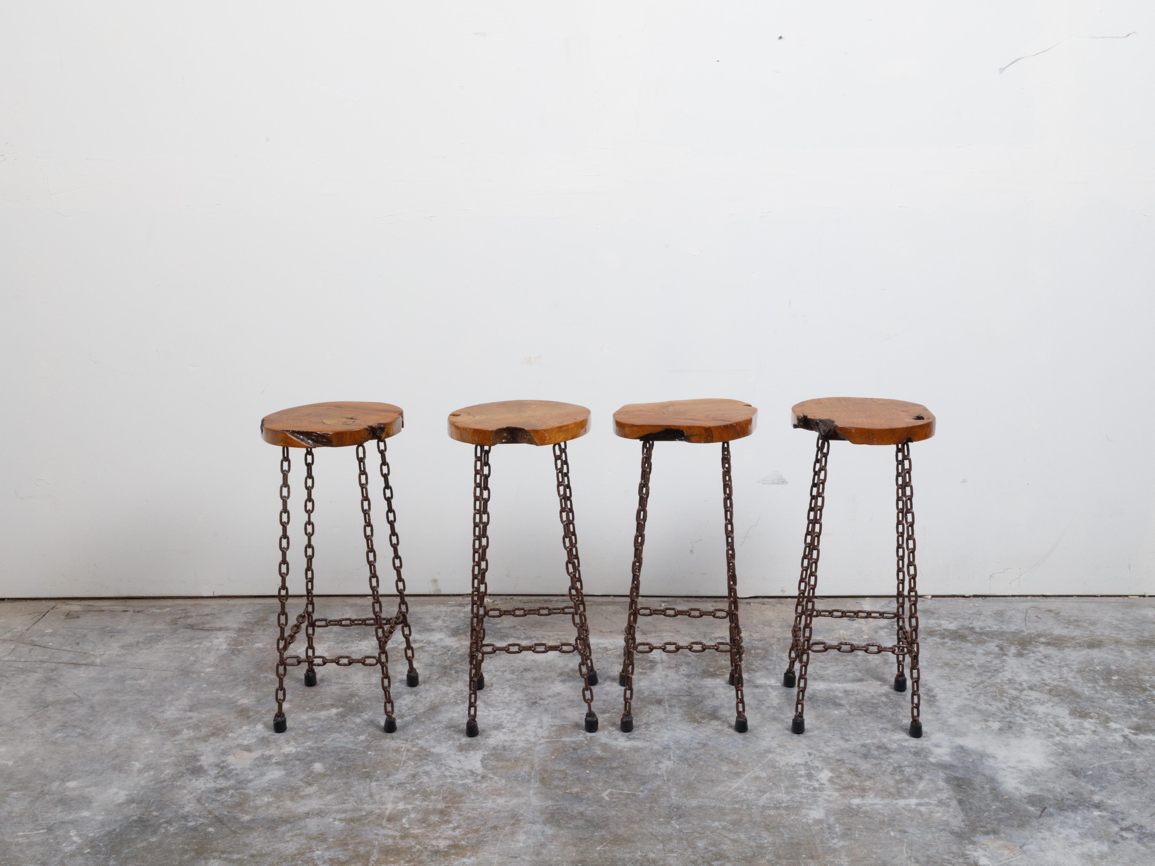 Four American chain stools from the 20th century with wood slab seats, priced and sold $1,125 each. Made in the USA during the 20th century, these stools each feature an irregular wood slab seat resting on four chain legs connected to one another