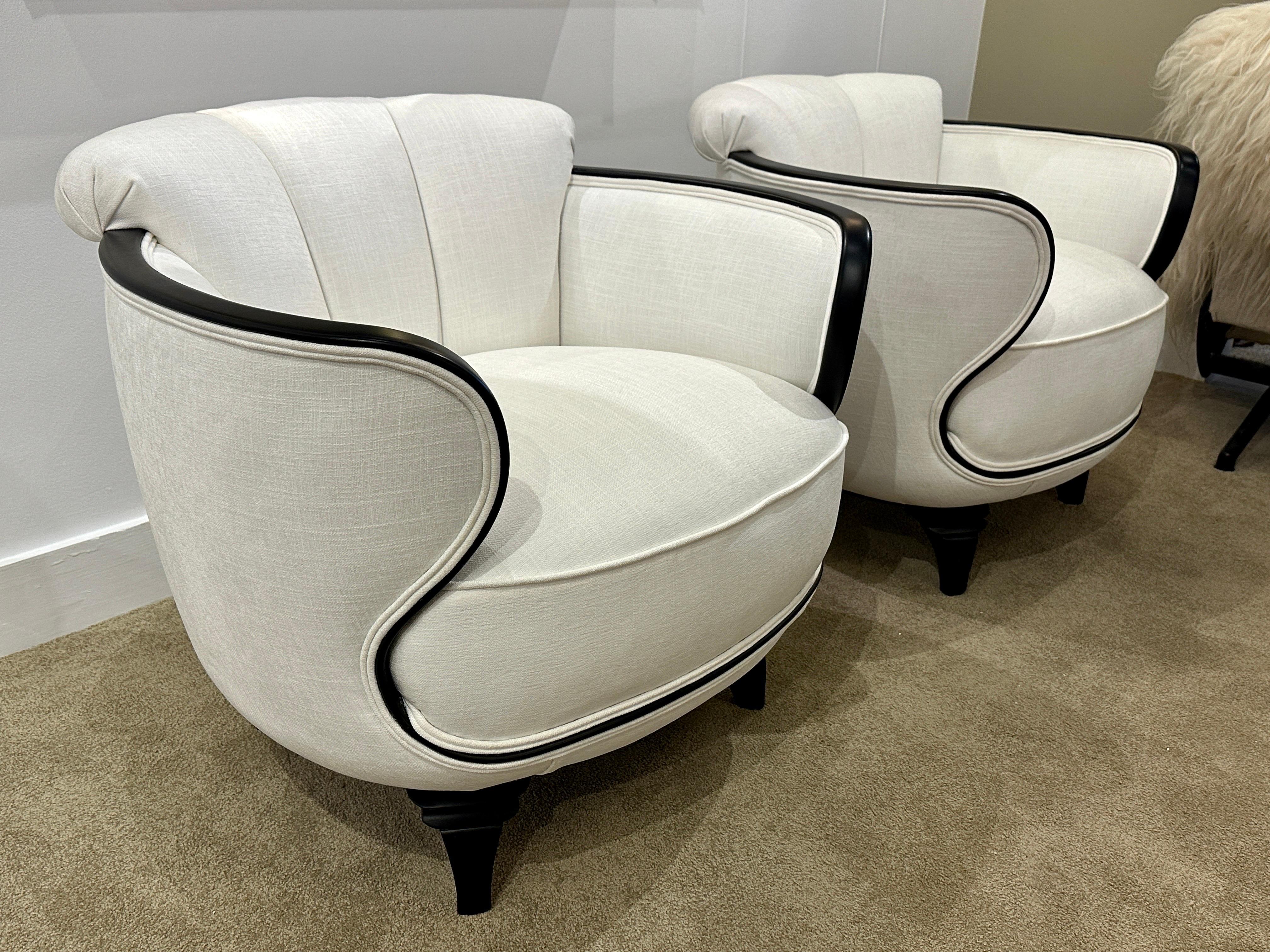 Pair of Art Deco oversized American designer chairs with an important ebonized wood trim and flared feet. Original design has been respected during re-upholstery by our experts. Luxurious and elegant all around - generous in scale and very