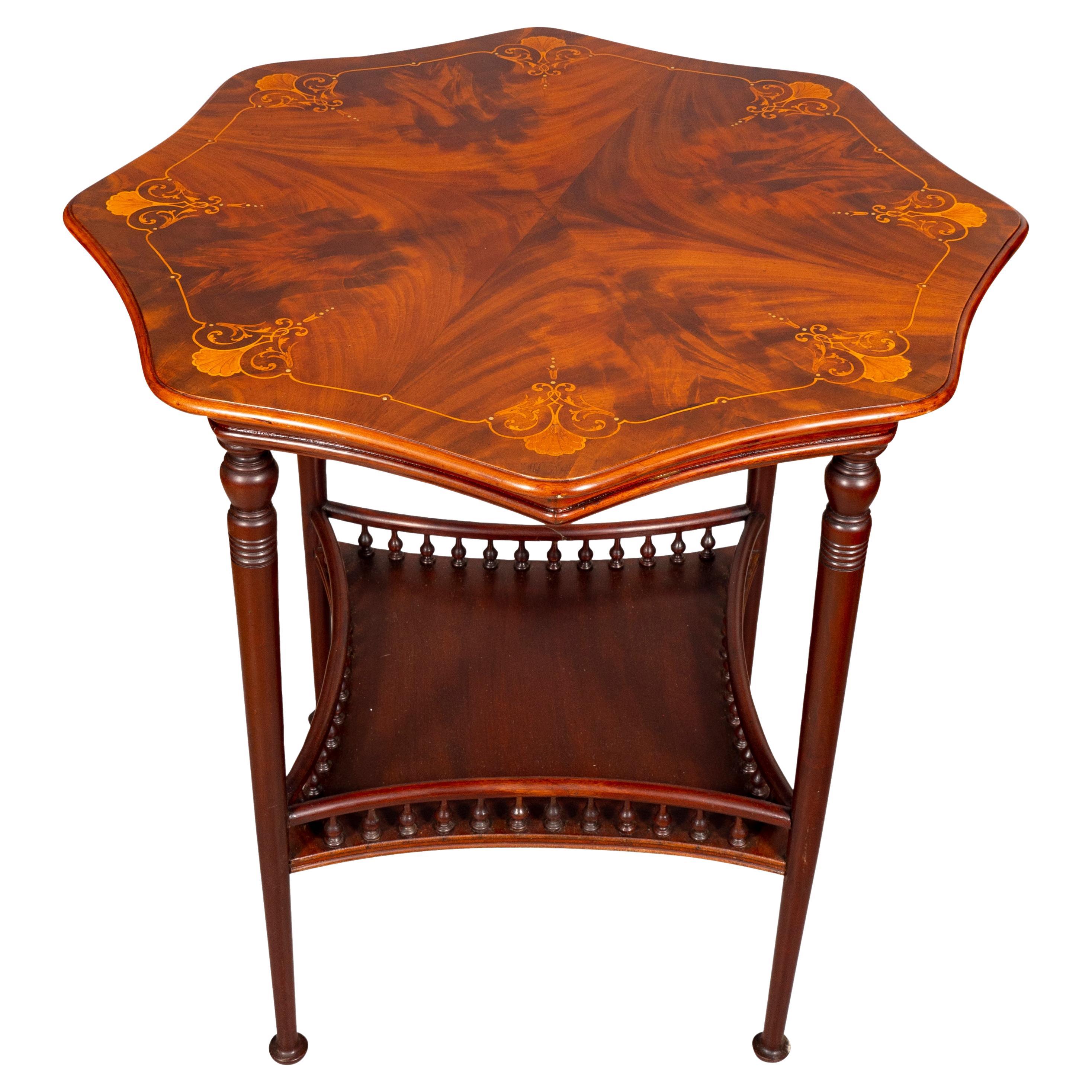 With a beautifully figured octagonal top inlaid with shell and volutes. With a conforming frieze raised on circular tapered legs joined by a lower shelf with spindle gallery. Ending on button feet.