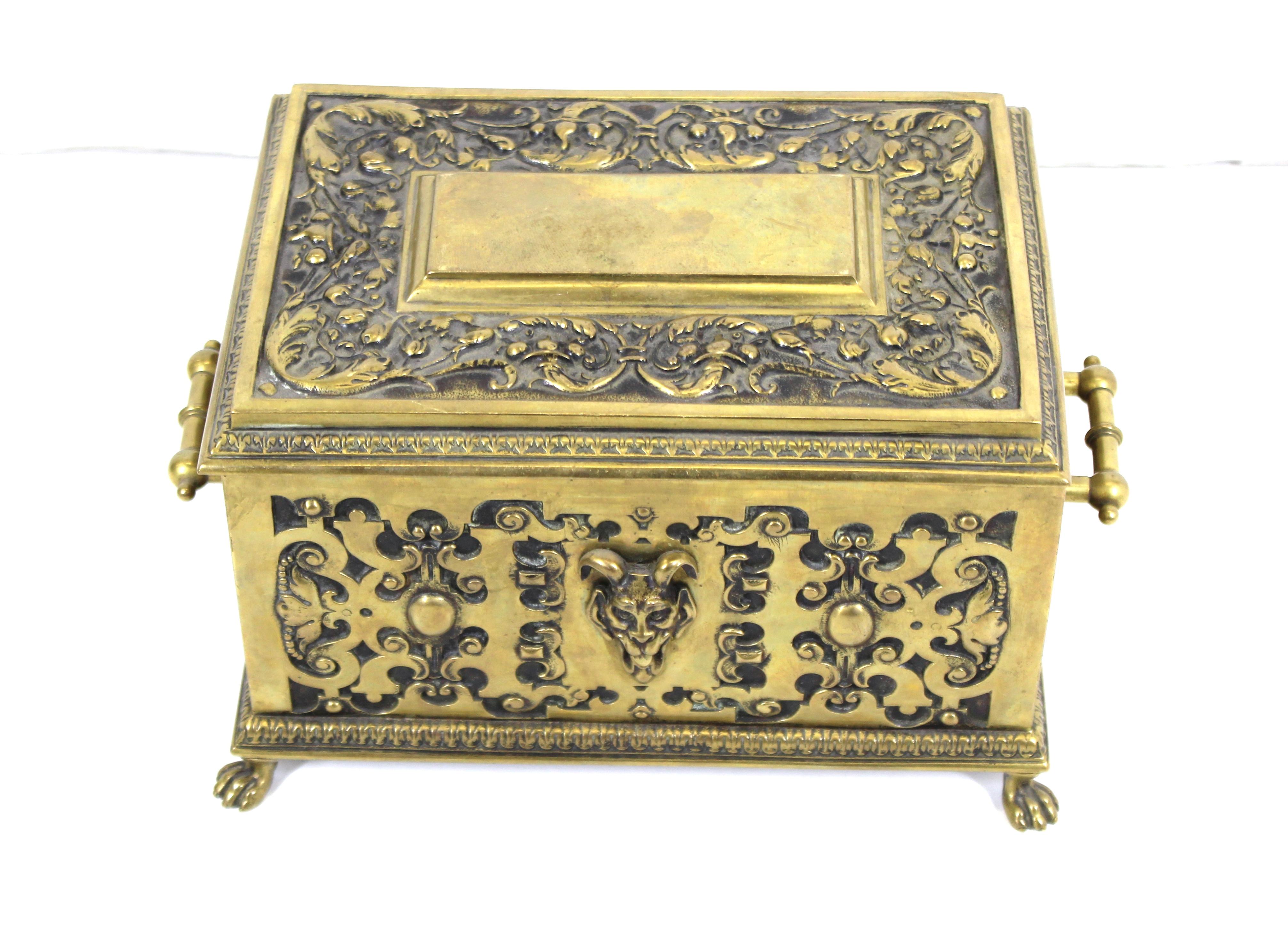 American Aesthetic Movement heavy cast bronze ornate casket humidor box. The piece has ornamental scroll-work and a grotesque head on the front and the back side. Interior walls are lined with cedar wood. Made in the United States during the 1870s,
