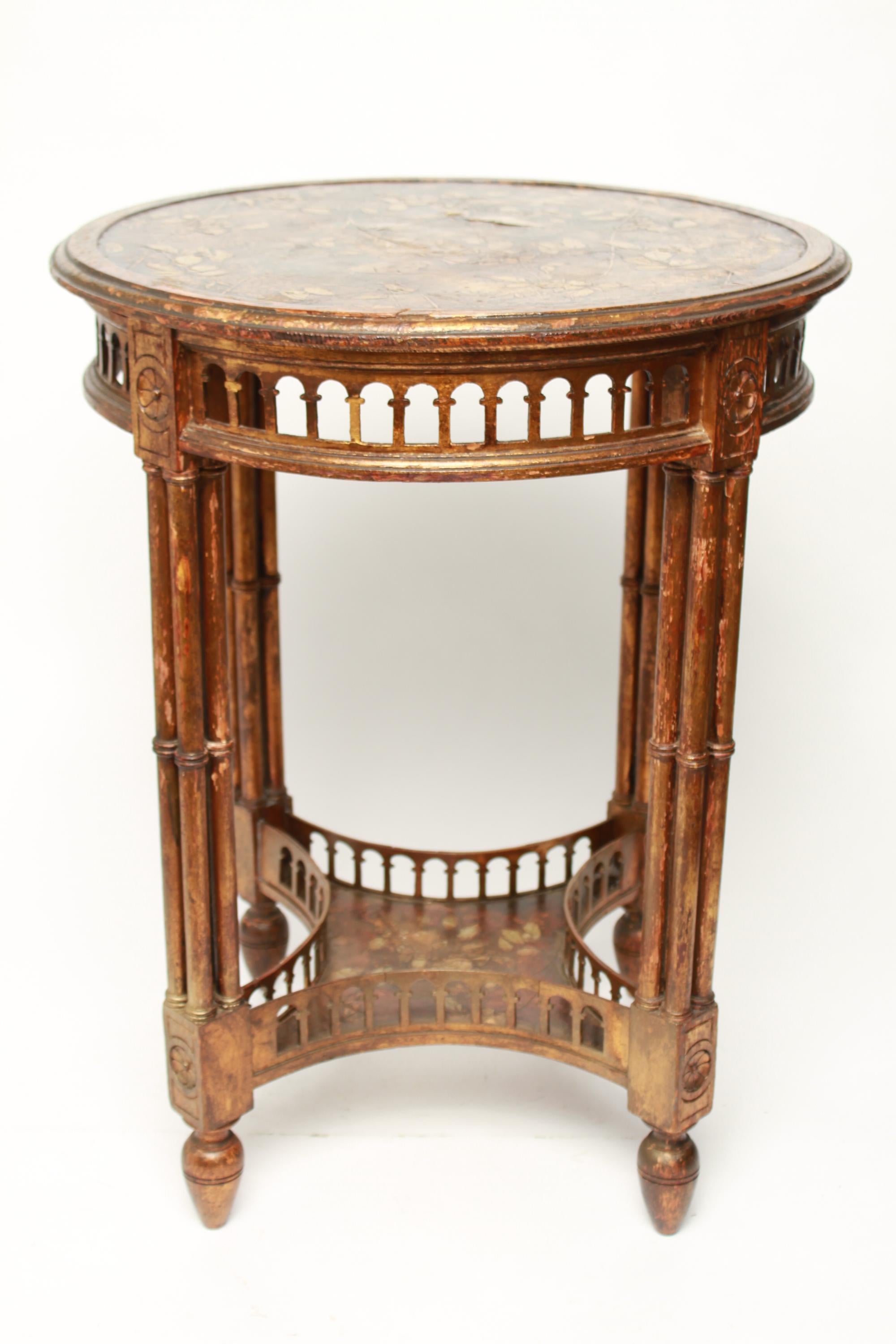 American Aesthetic Movement circular side table with parcel giltwood, decorated with Japonisme themed song birds and floral sprigs and open-work frieze below top rim and gallery on lower shelf. The piece is in great vintage condition.