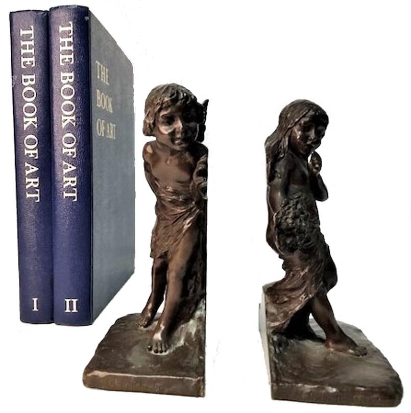 A charming set of bronze bookends. One of the bookends depicts a figure of a young girl with a questioning face expression, holding a bouquet; and the other a cupid, who peeks around the edge of the books at the girl.

Object: A set of sculptural