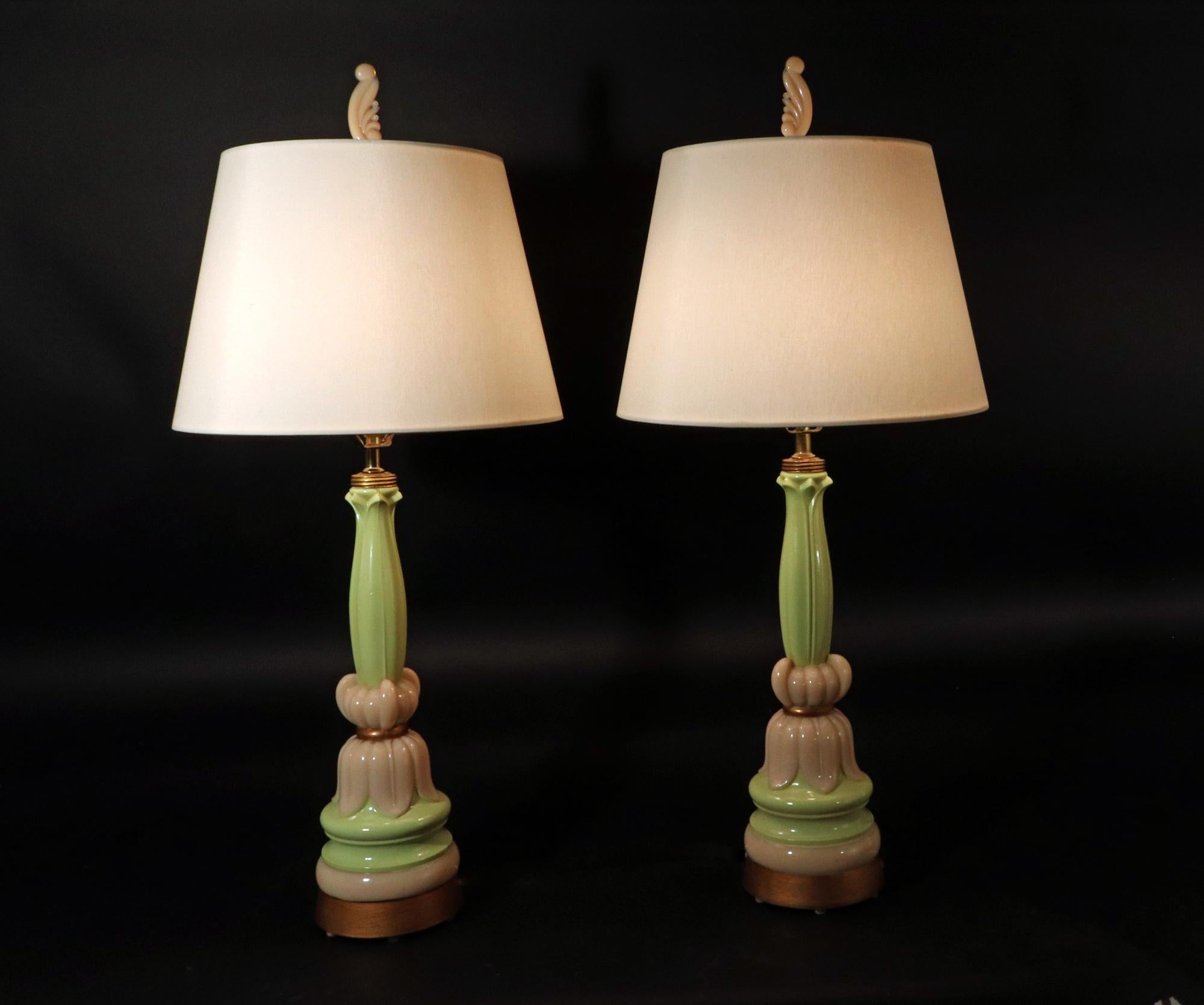 Vintage Aladdin Alacite Glass Lotus Flower Inspired Lamps,
 Original Alacite Glass Finials, 
American
A Pair,
Circa 1938-42

The Aladdin Alacite glass lamps in green and ivory.  The center with a lotus flower in ivory on a green leaf topped column. 