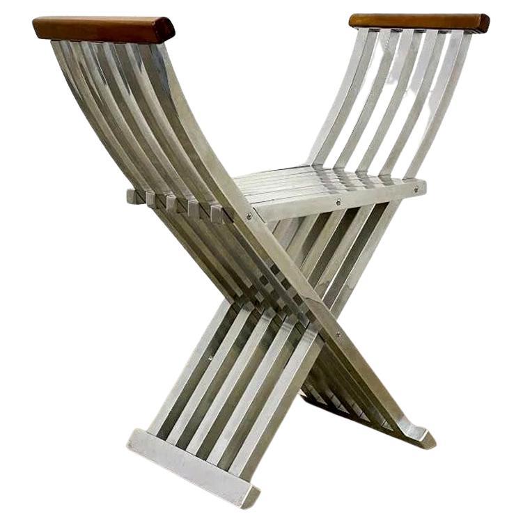 A collector's delight. Designed by John Vesey (1924-1992) circa 1958, the form of this folding bench/chair was inspired by antique Savonarola chair, yet both the design and the choice of material were radically modern. Constructed in square aluminum