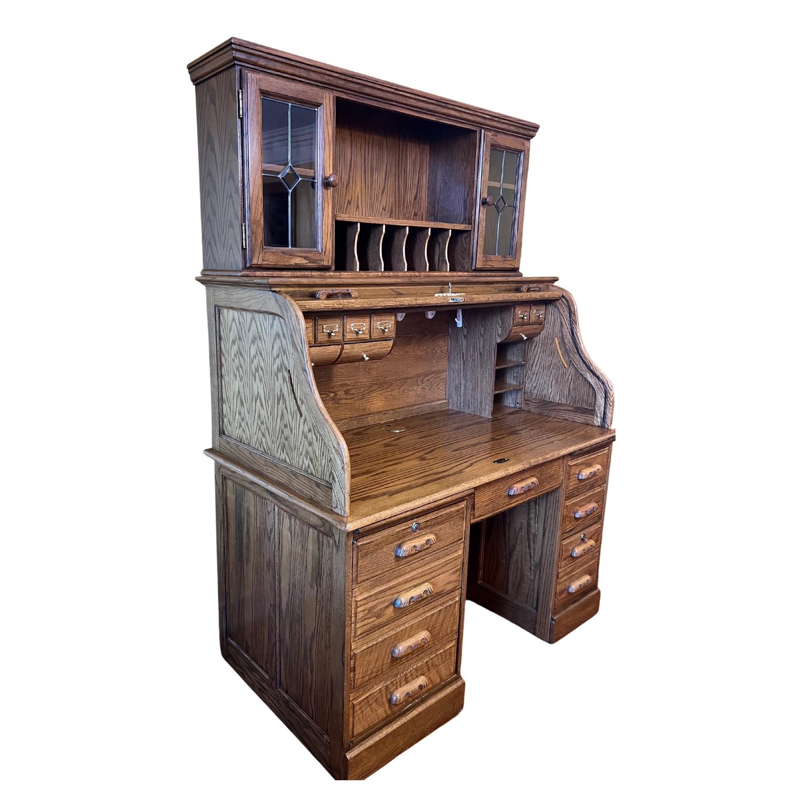 Made in American this reproduction of an antique style desk has all the bells for modern day use but looks like an antique, comes with keys to both roll top and below drawers, desk has 9 small drawers with 2 consoles, bottom of desk has one side