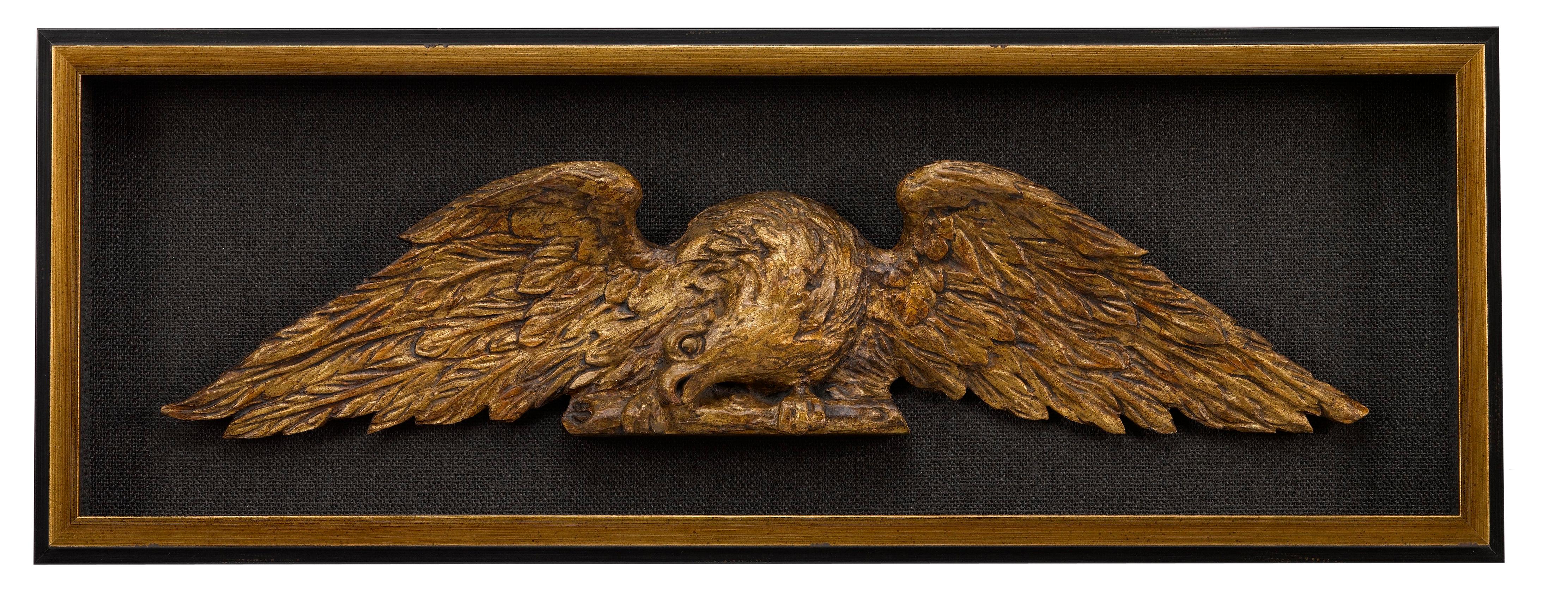 This is a pair of hand-carved American eagles, a beautiful matched architectural set. The pair was designed to be mounted over doorways or between columns. Each eagle is displayed with wings fully extended, one faces to the right, the other to the