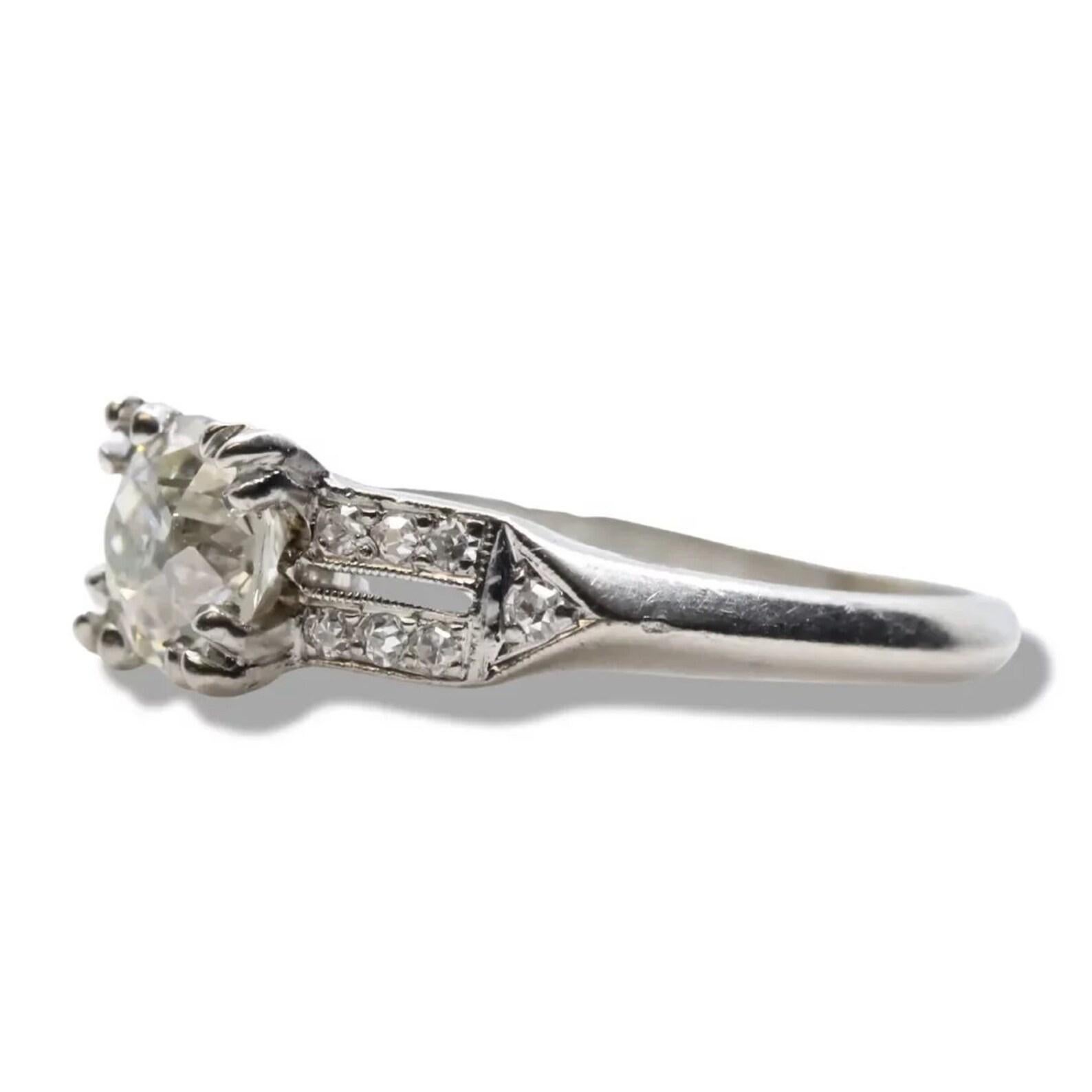 A handmade original Art Deco period diamond engagement ring in platinum. Centered by a 0.80 carat antique European cut diamond of G color and VS2 clarity secured by handmade claw form prongs. Framing the center diamond are fourteen pave set