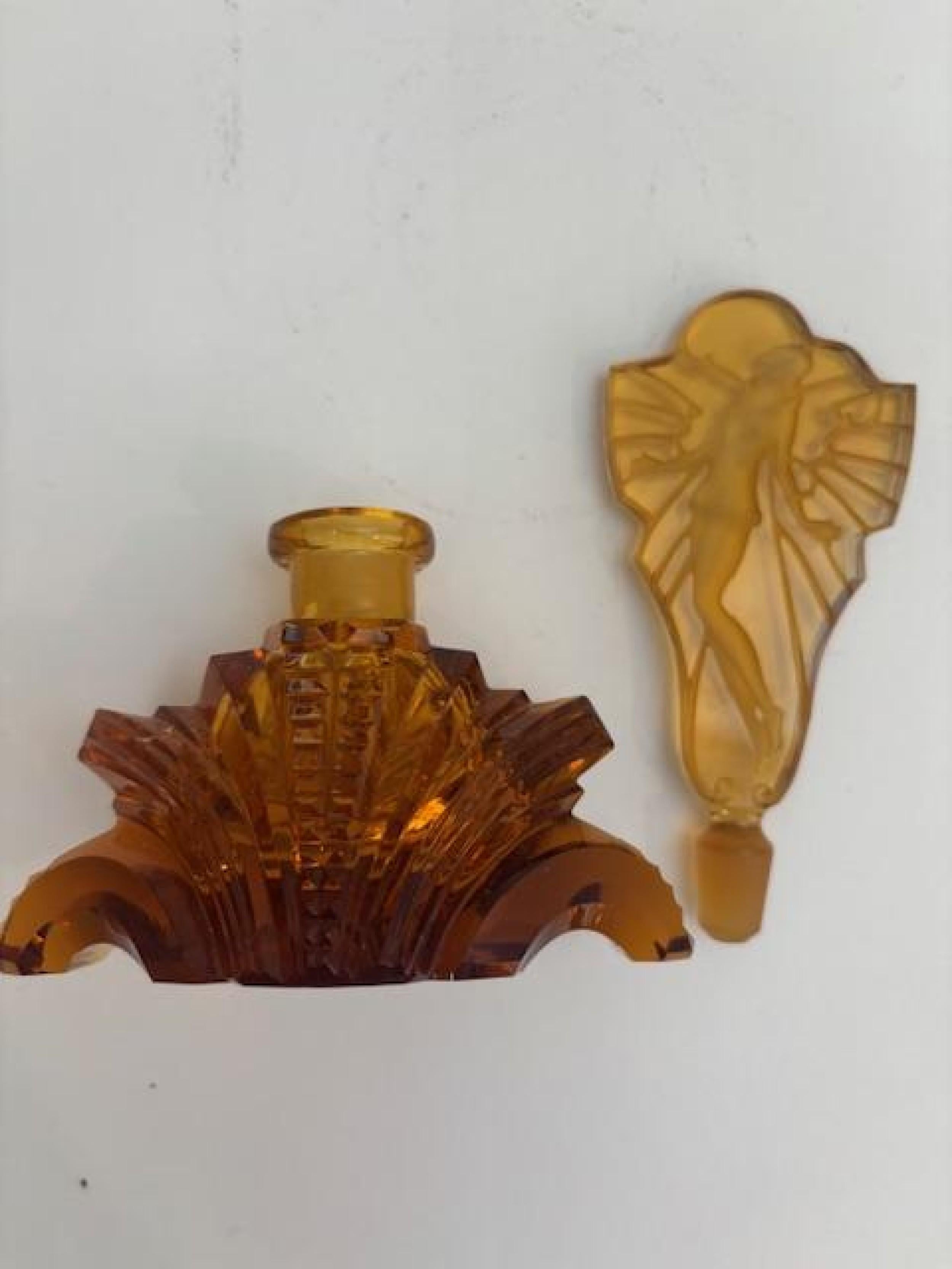 American Art Deco amber cut glass perfume bottle with flaired design base supporting a stopper with an etched figure of a lady